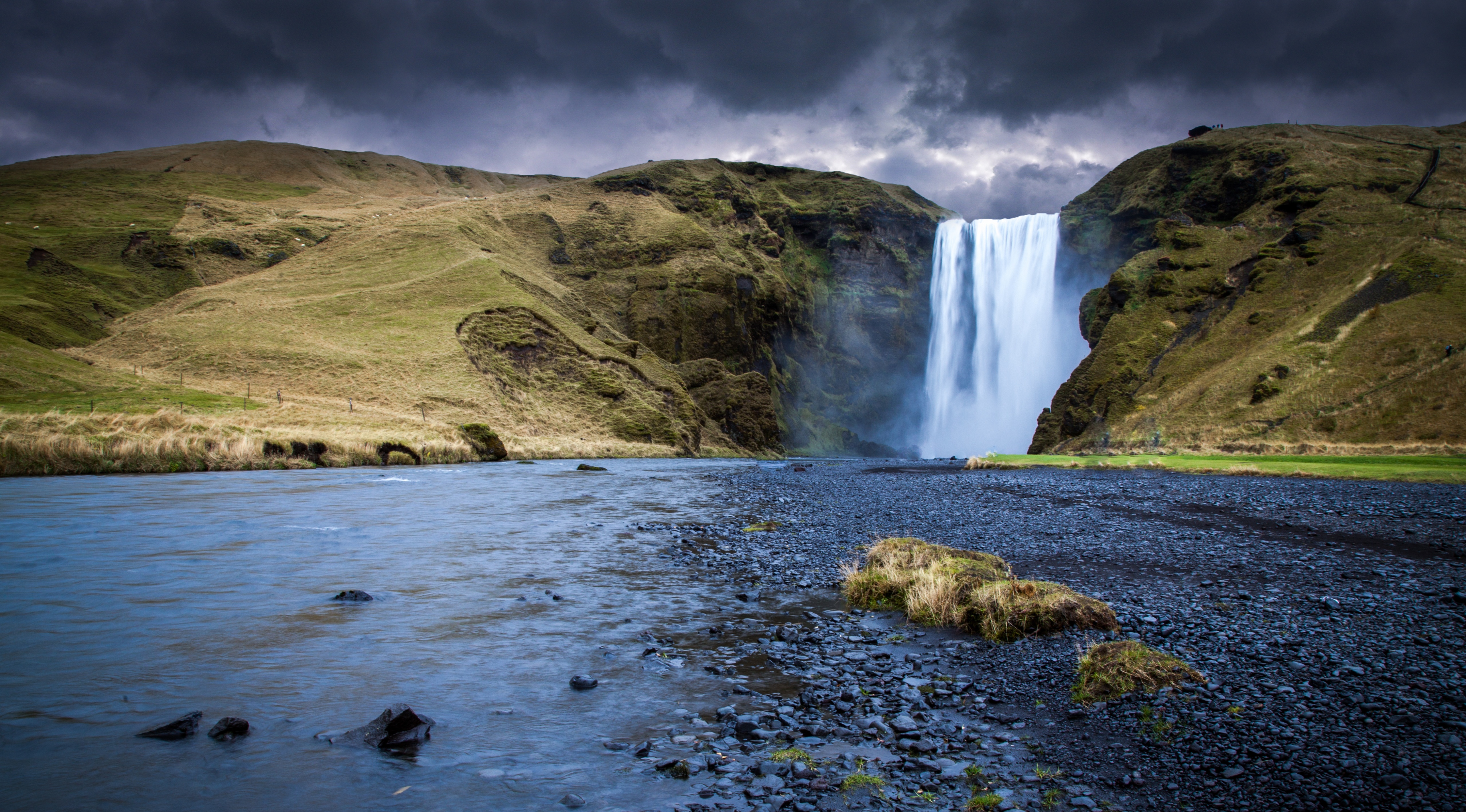 Skógafoss Waterfall in Iceland under stormy skies HD Wallpaper