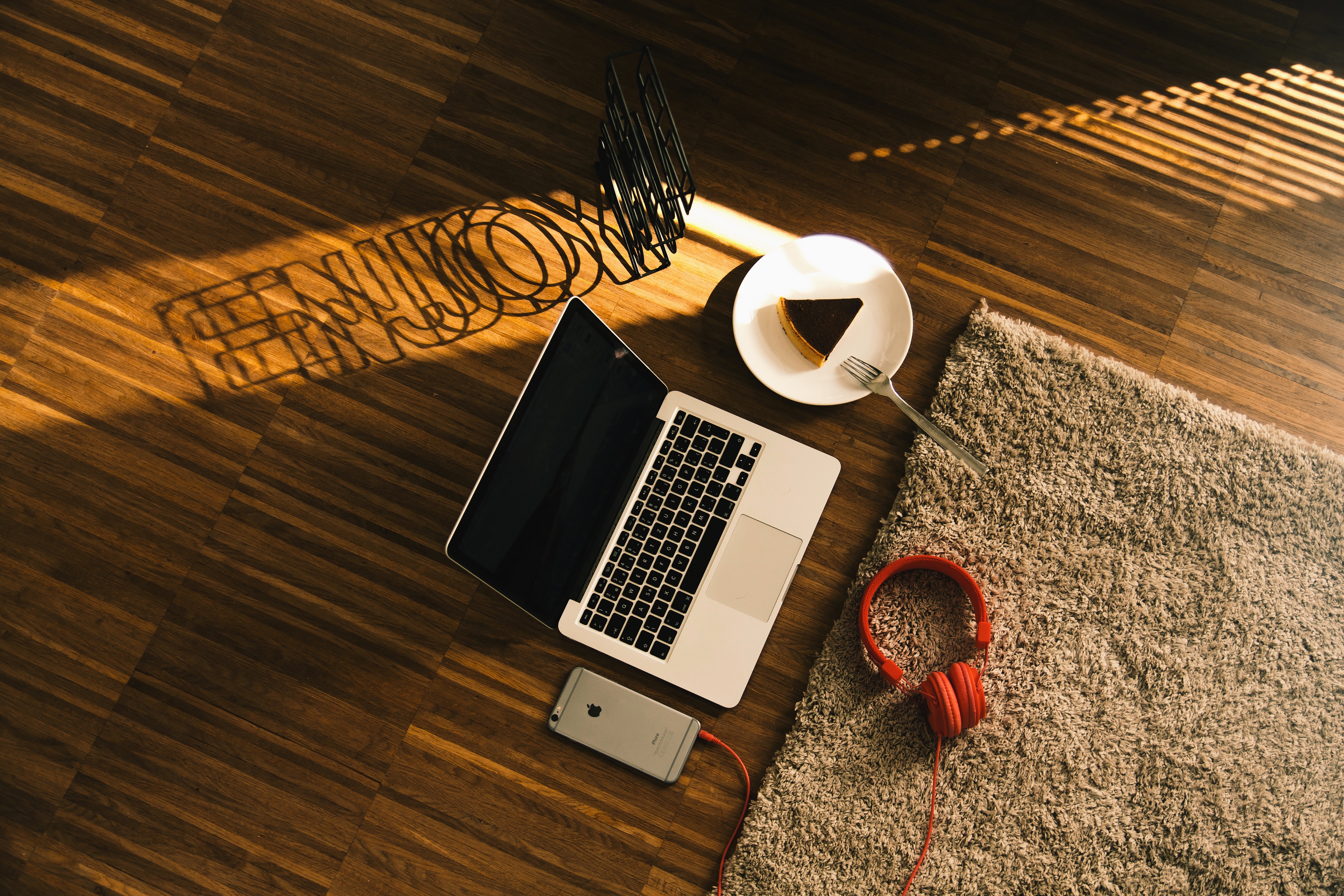 MacBook, iPhone, Cake, Headphones, and Rug on Floor HD Wallpaper