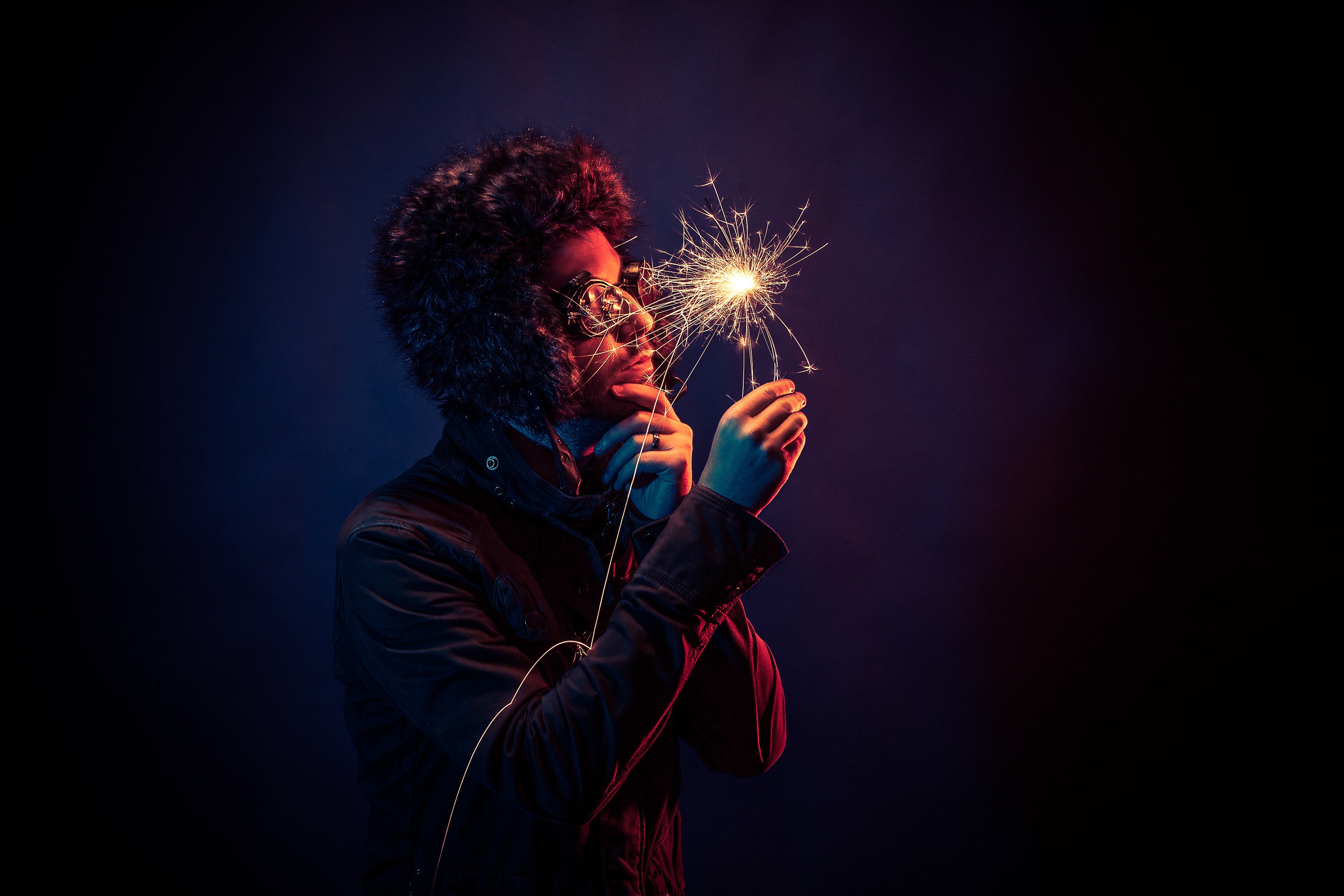 Man in bomber hat holding a sparkler HD Wallpaper