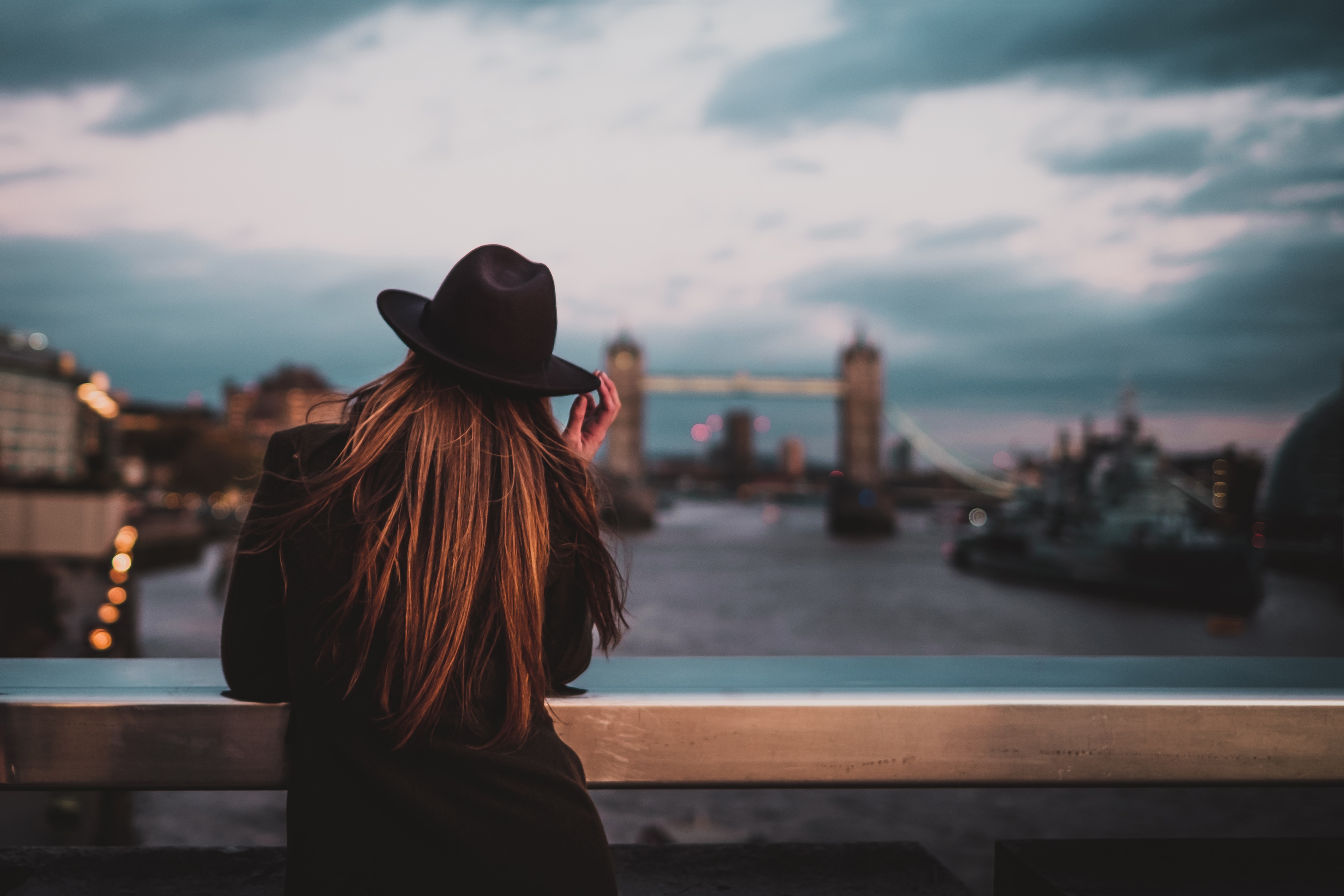 Woman in hat looking at Tower Bridge at dusk HD Wallpaper