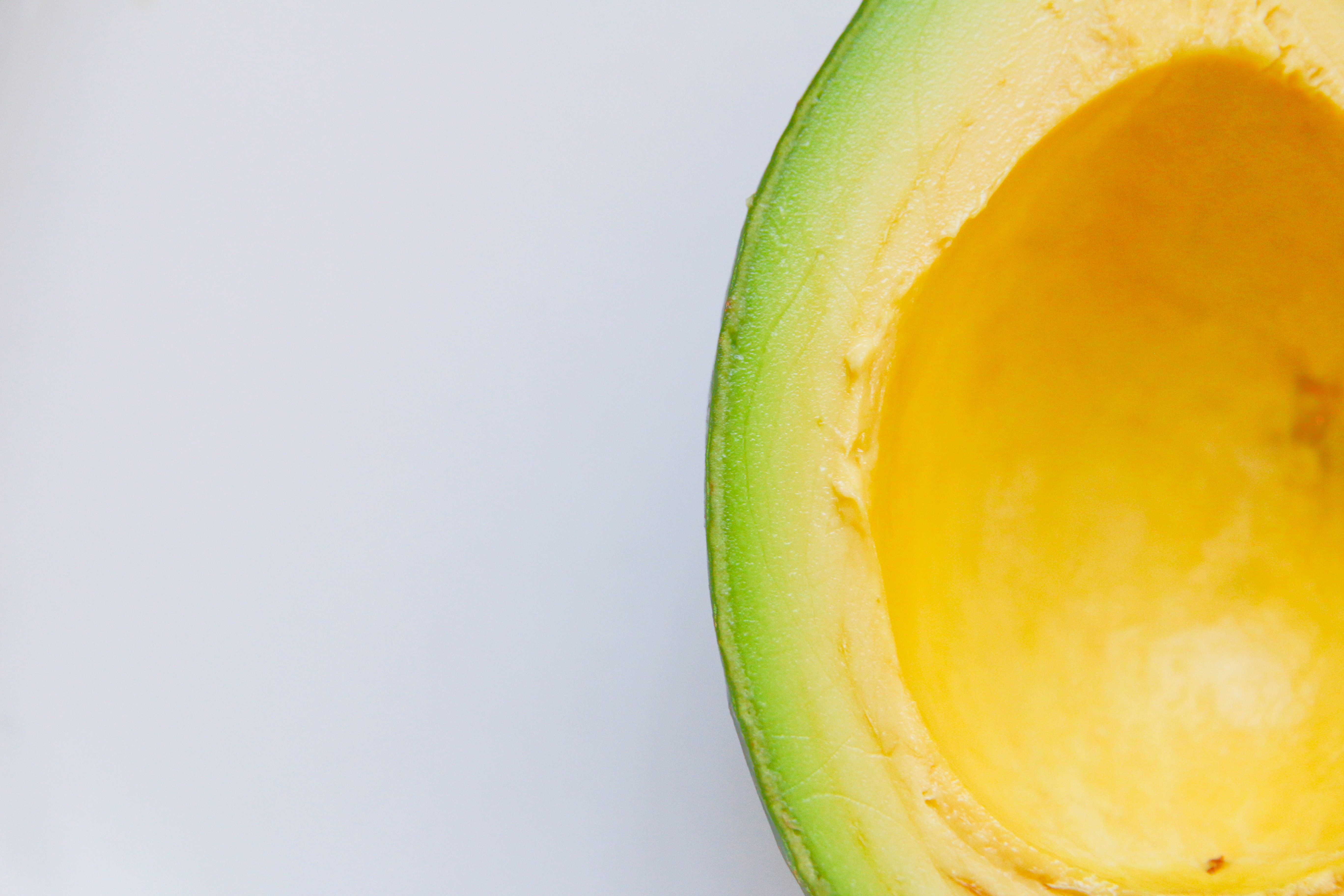 Close-up of a sliced avocado with bright yellow flesh HD Wallpaper