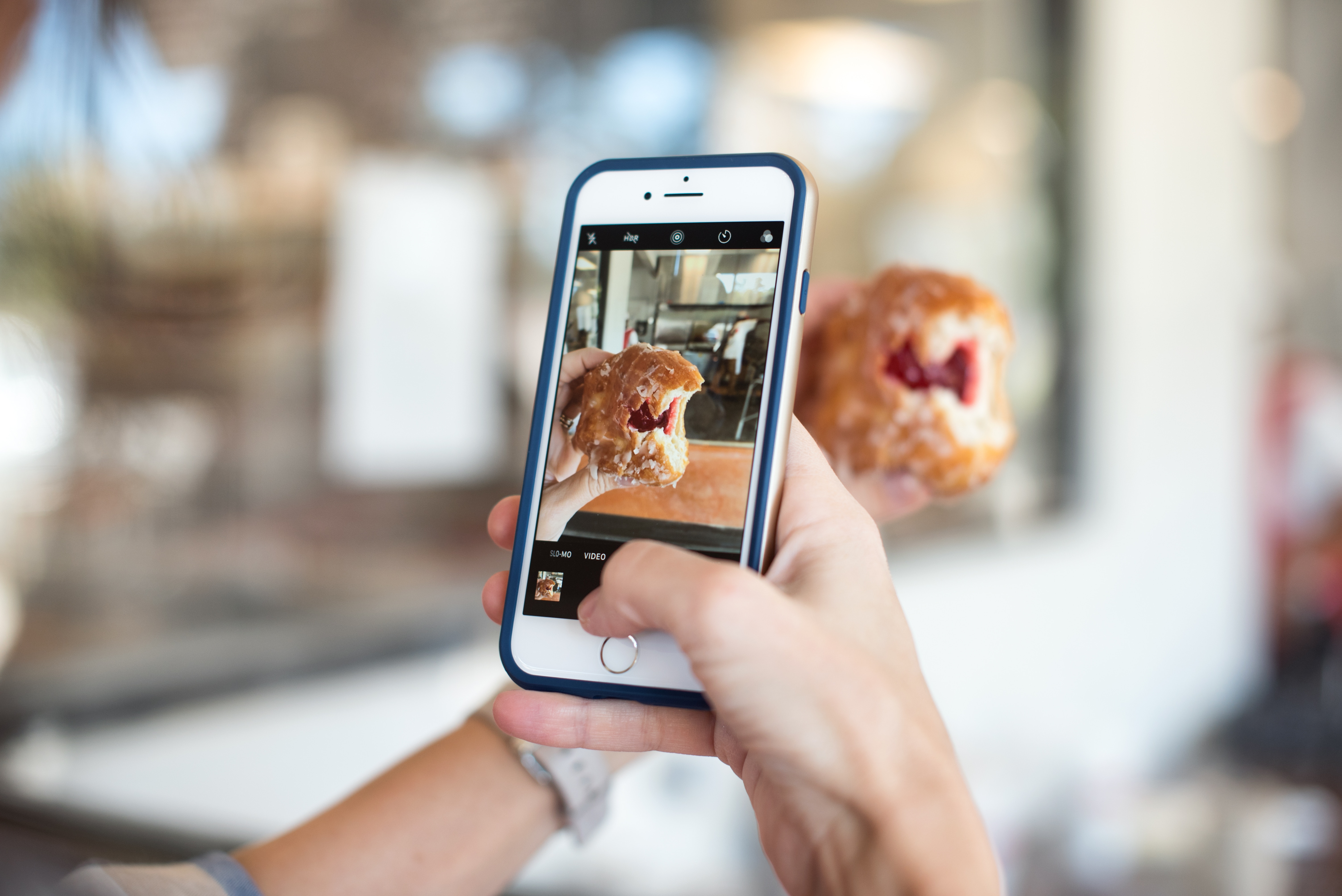 Person taking a photo of a donut with an iPhone HD Wallpaper