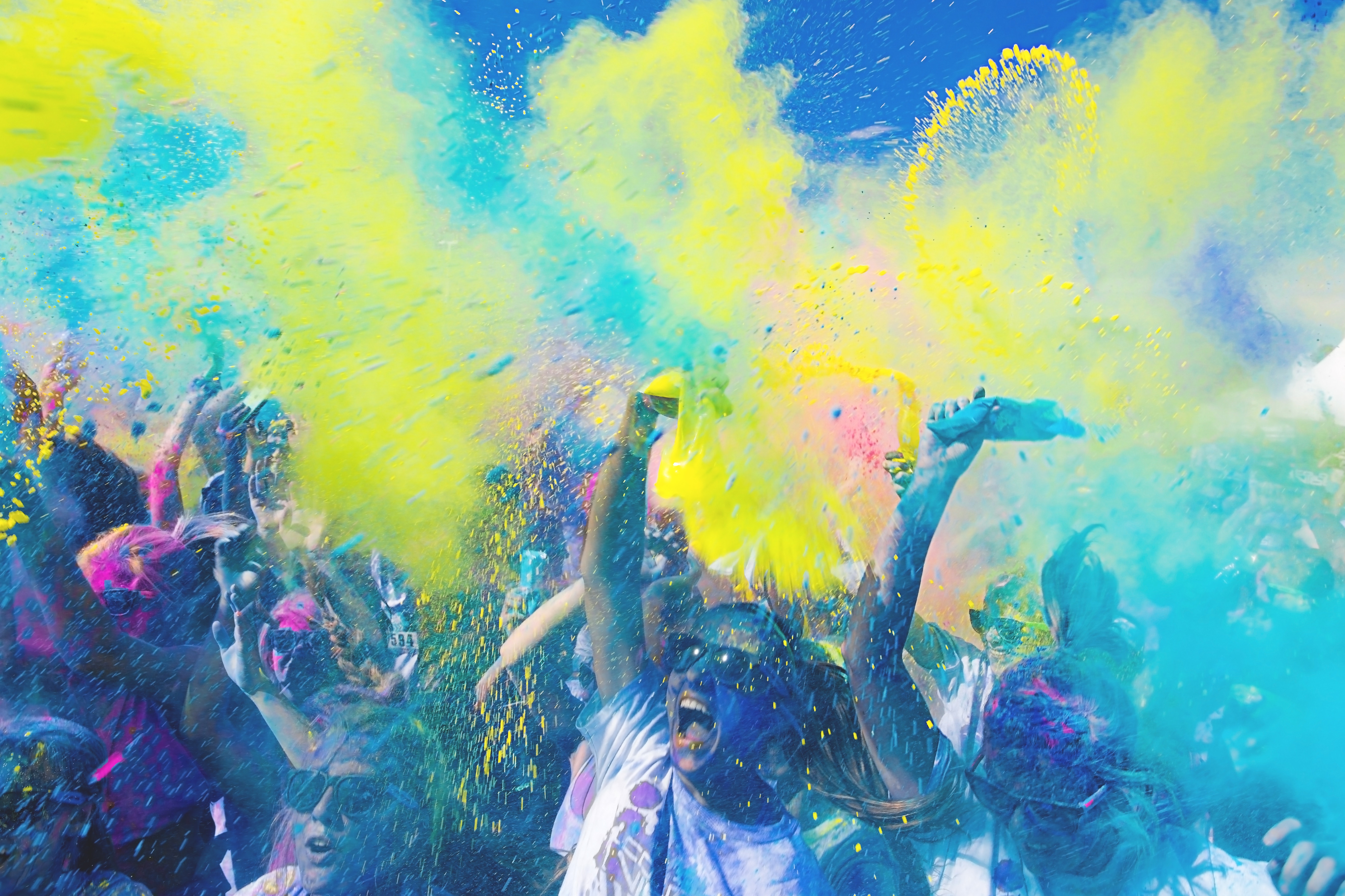 People throwing colorful powder at a color run HD Wallpaper