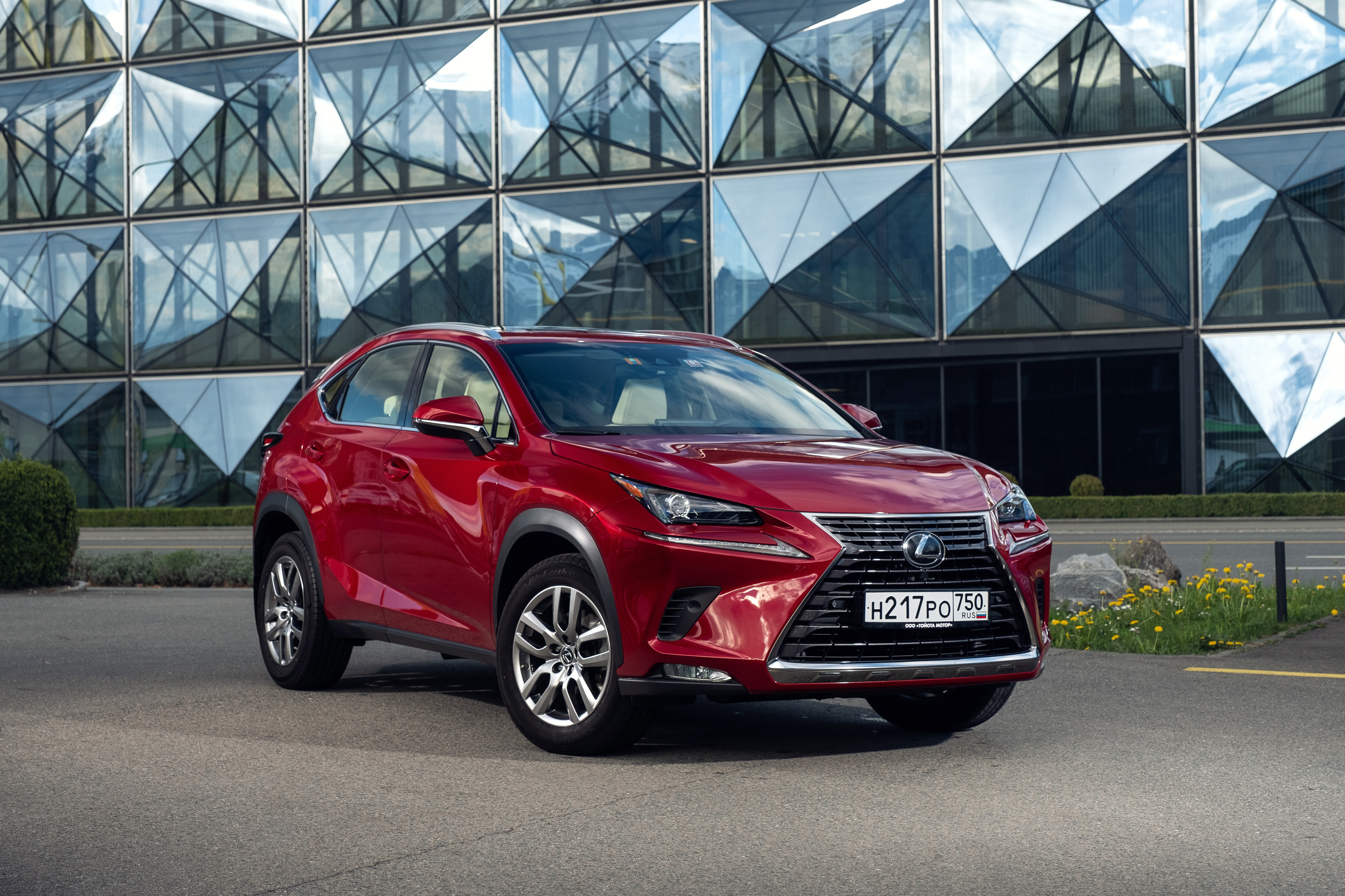 Red Lexus NX SUV parked in front of a modern building HD Wallpaper