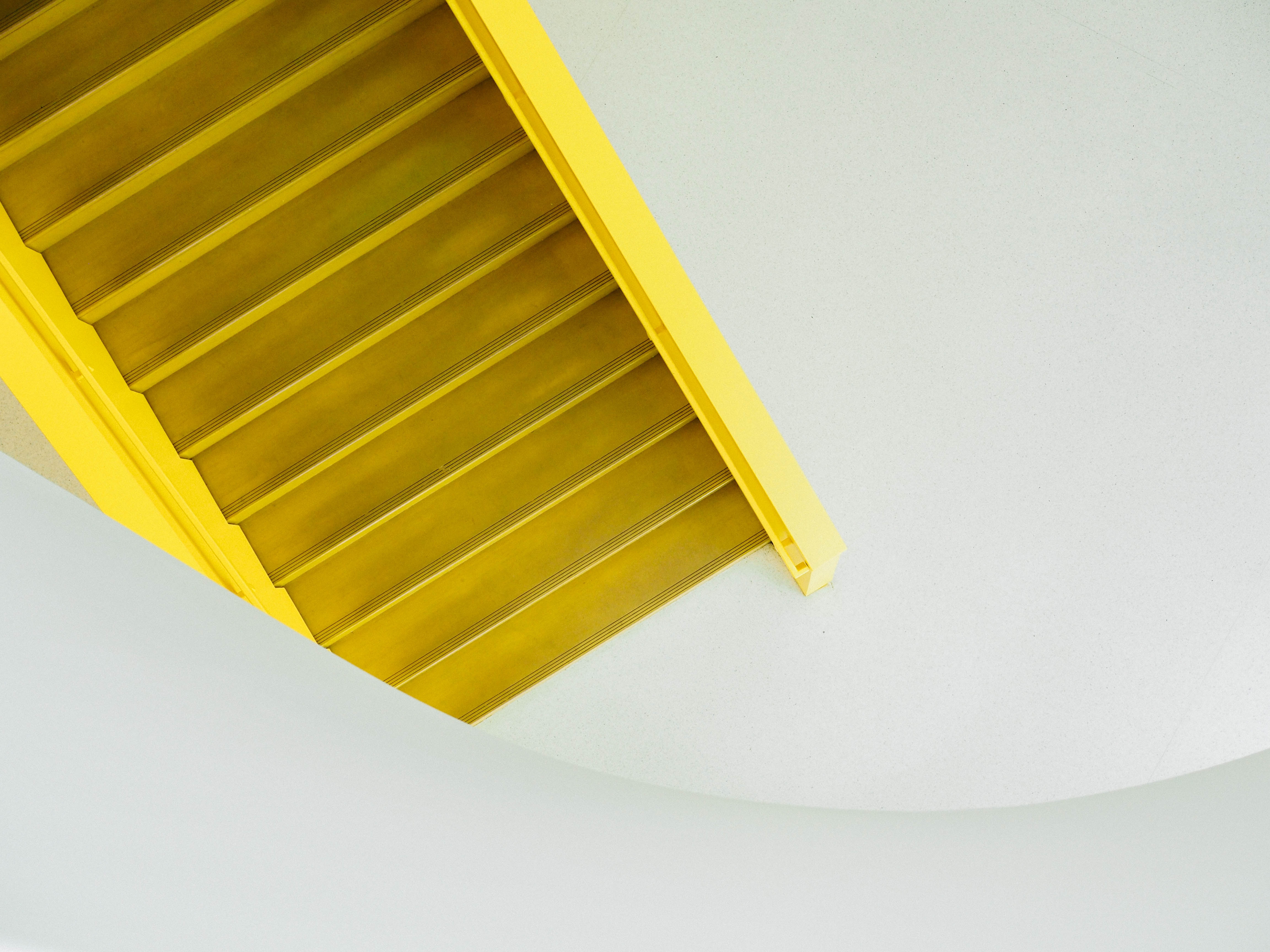 Yellow staircase against a white wall HD Wallpaper