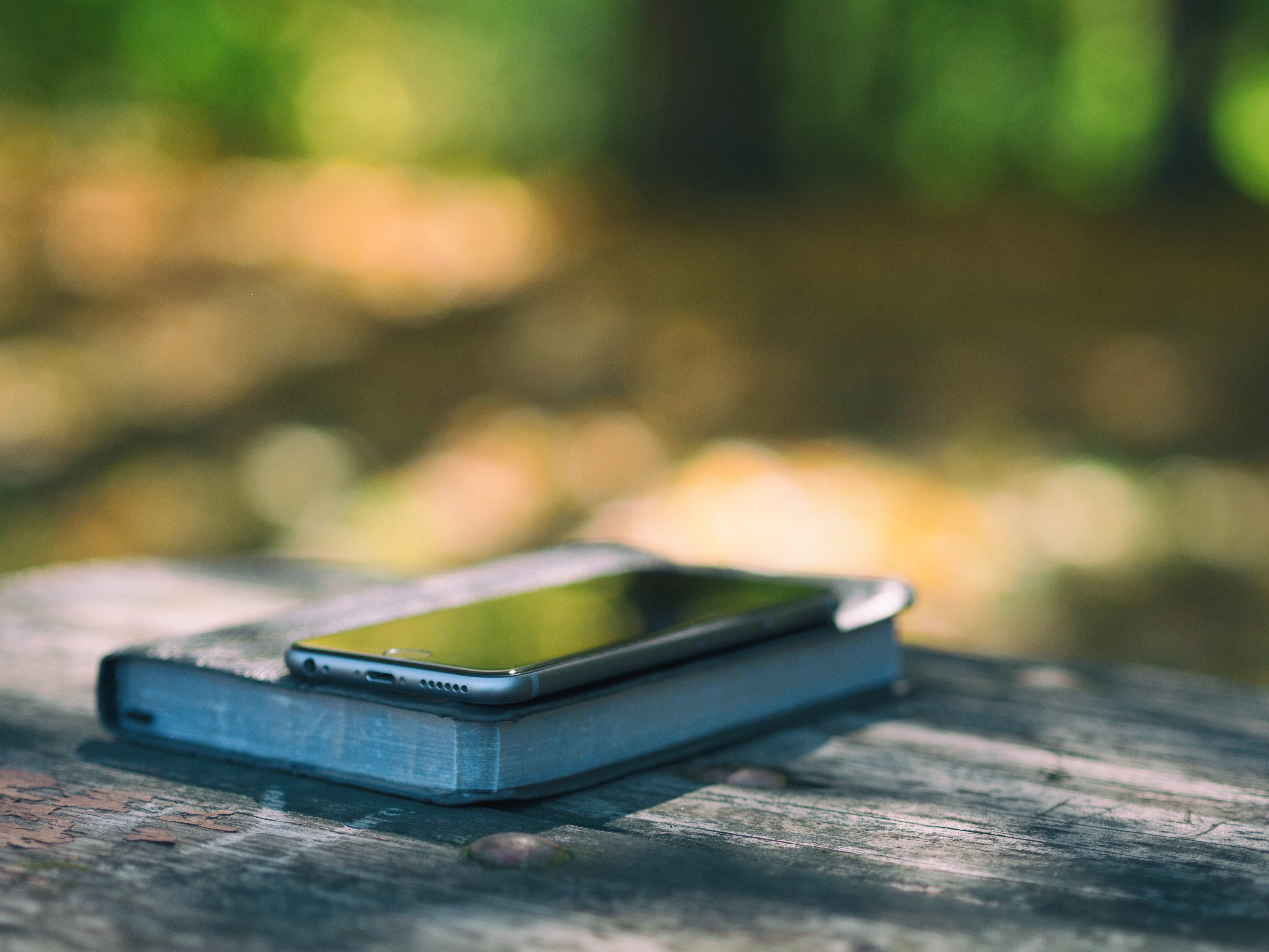 iPhone on a book on a wooden table HD Wallpaper