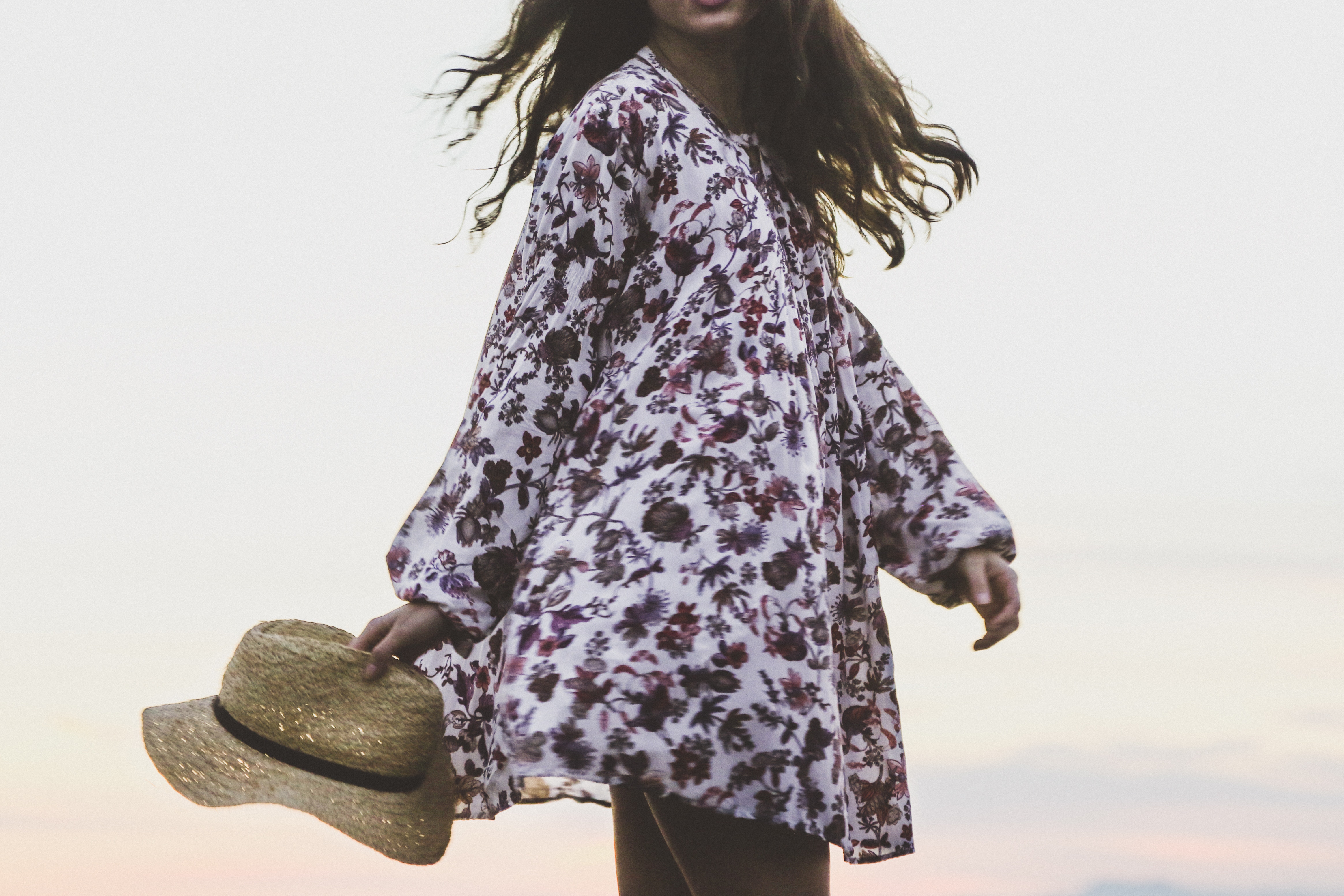 Woman in floral dress holding a straw hat HD Wallpaper
