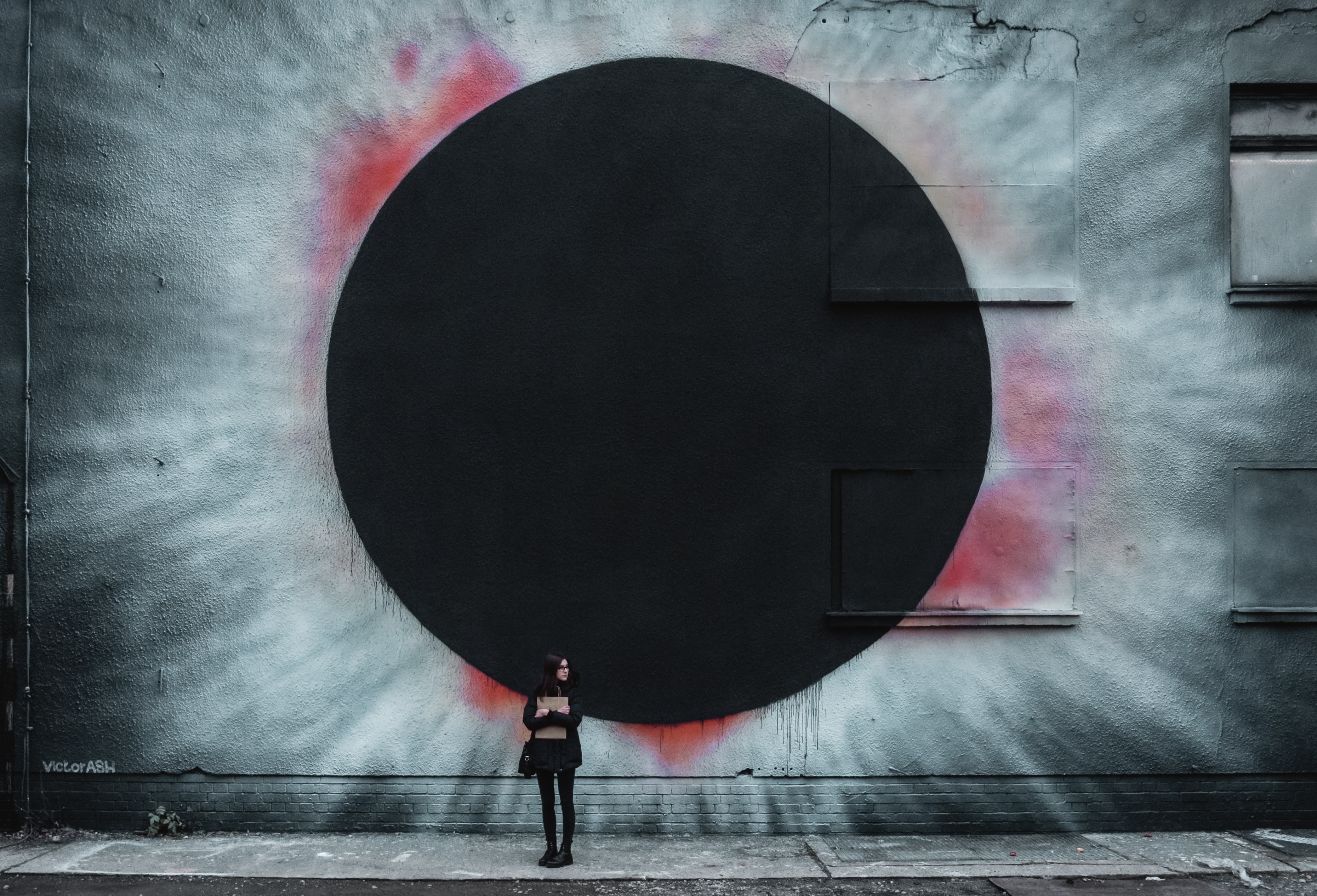 Girl in front of a large eclipse mural in Berlin HD Wallpaper