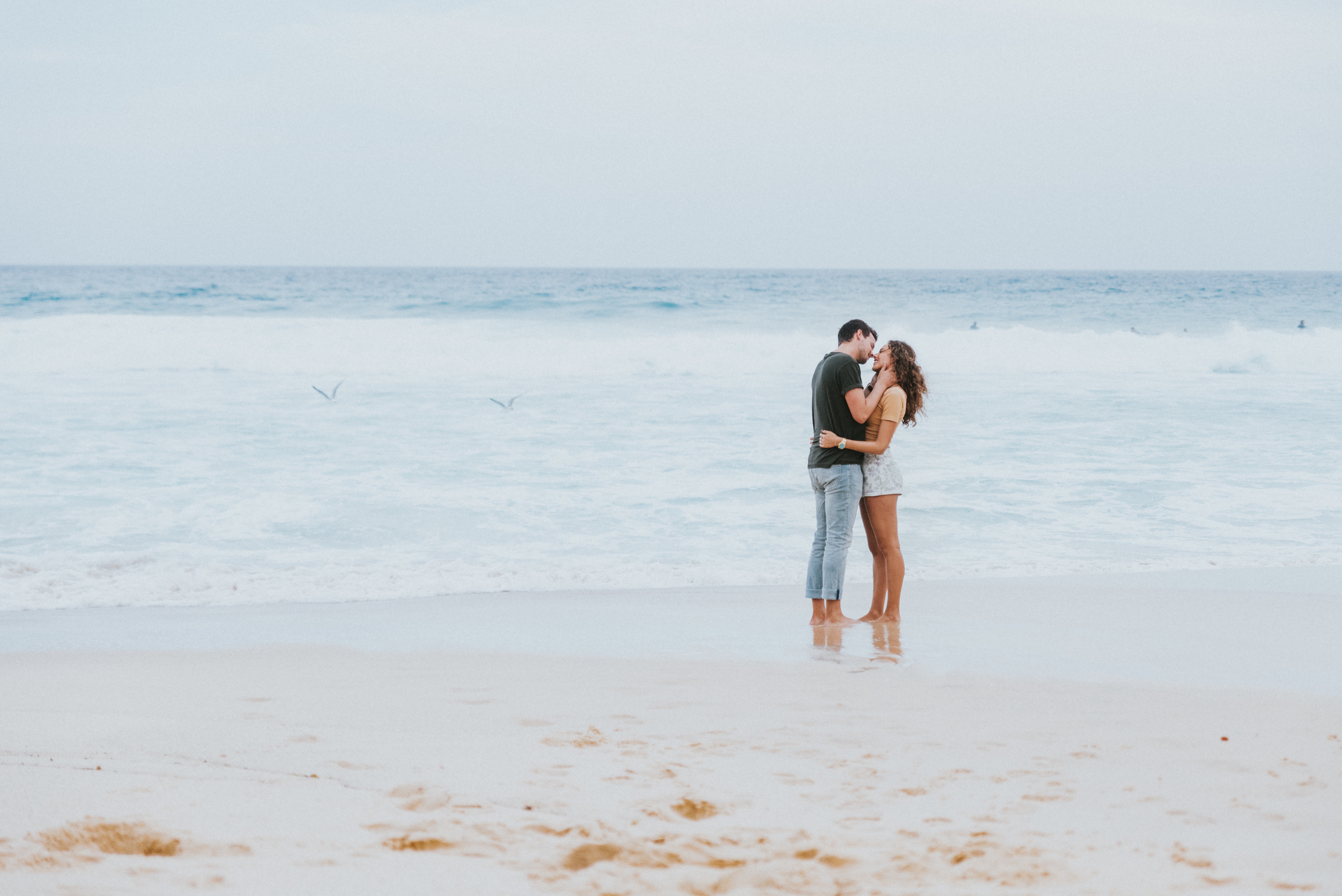 Couple kissing on the beach with waves HD Wallpaper