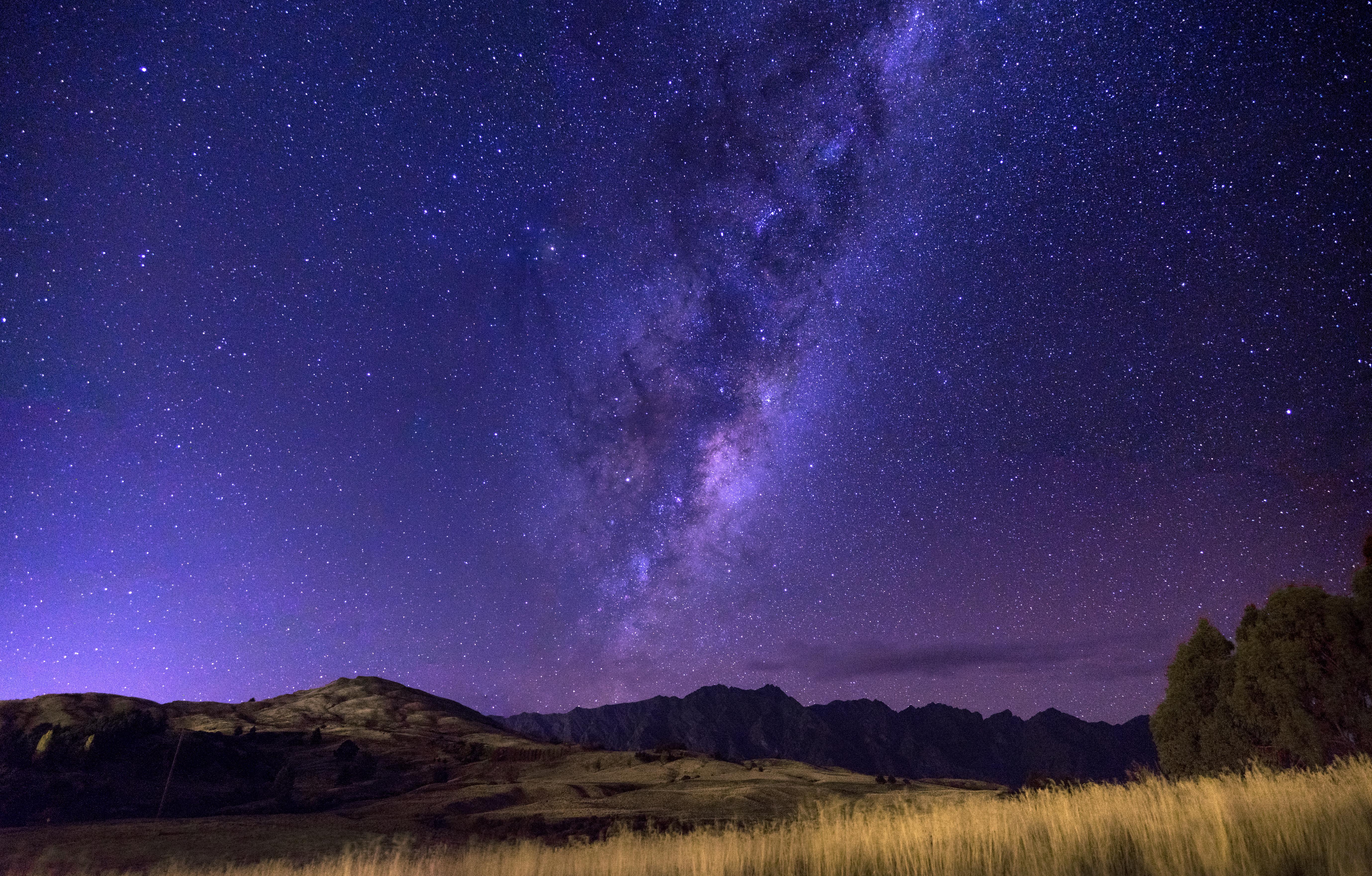 Milky Way Galaxy over Mountains and Grasslands at Night HD Wallpaper