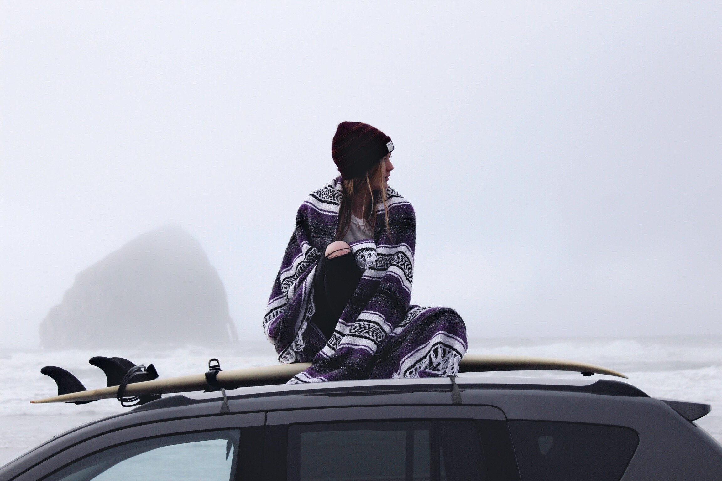 Woman in blanket on car roof with surfboard HD Wallpaper