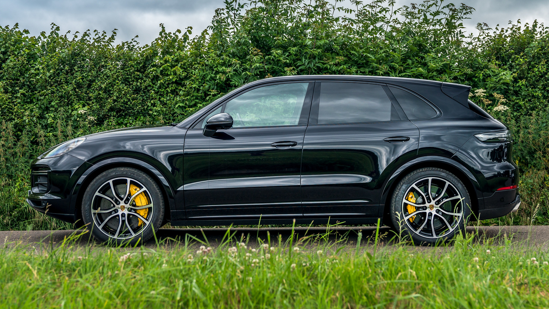 Black Porsche Cayenne Turbo SUV parked by a hedge HD Wallpaper