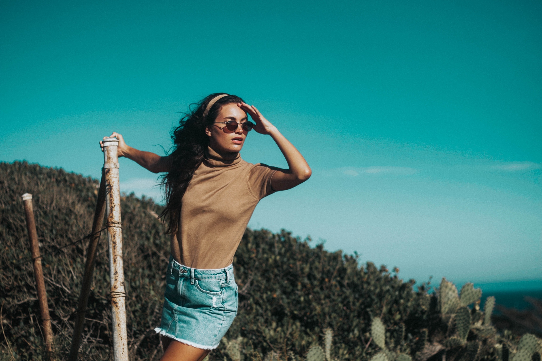 Woman in denim skirt and turtleneck on a hillside HD Wallpaper