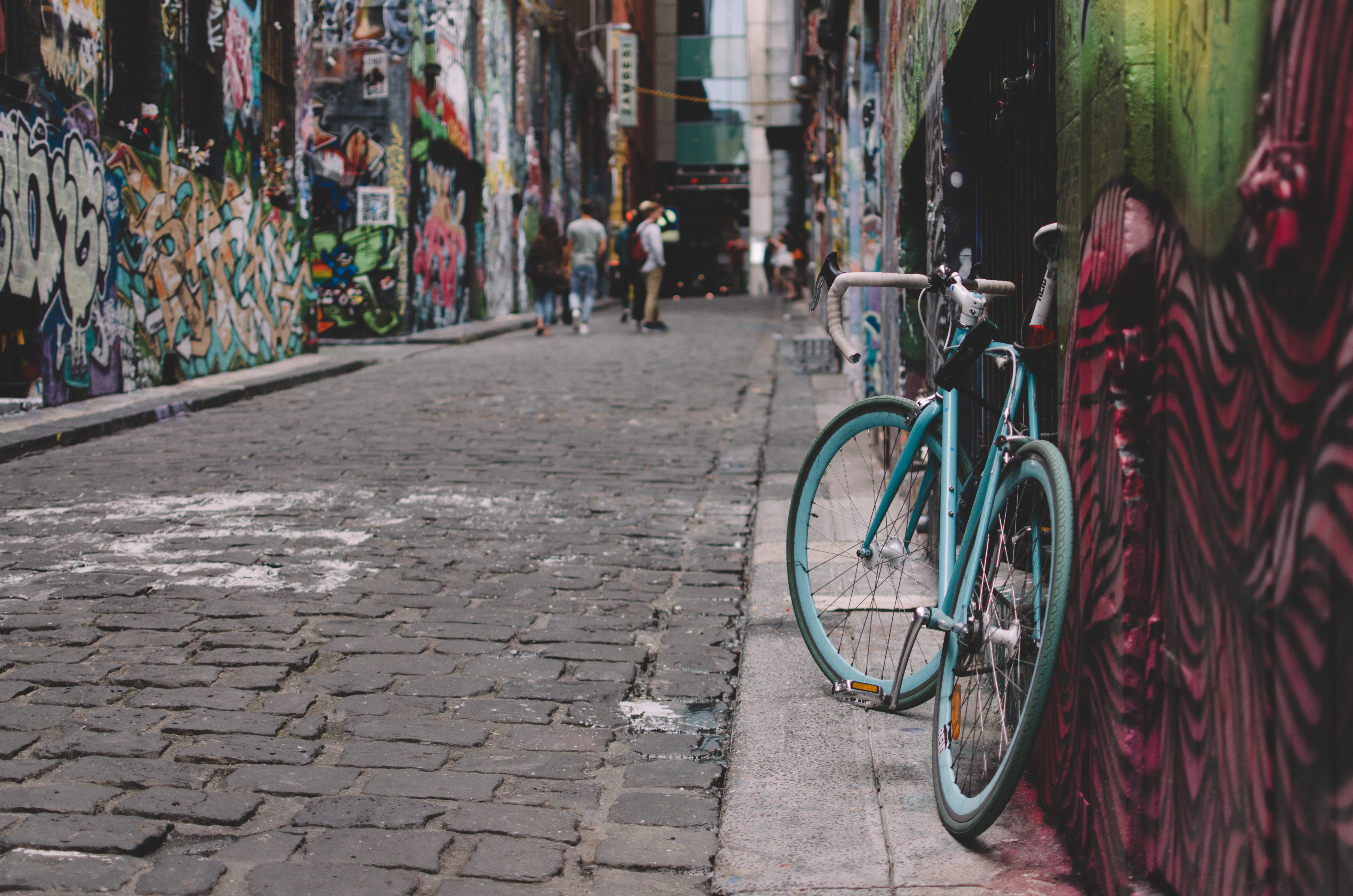 Blue bicycle parked in a graffiti-covered Melbourne laneway HD Wallpaper