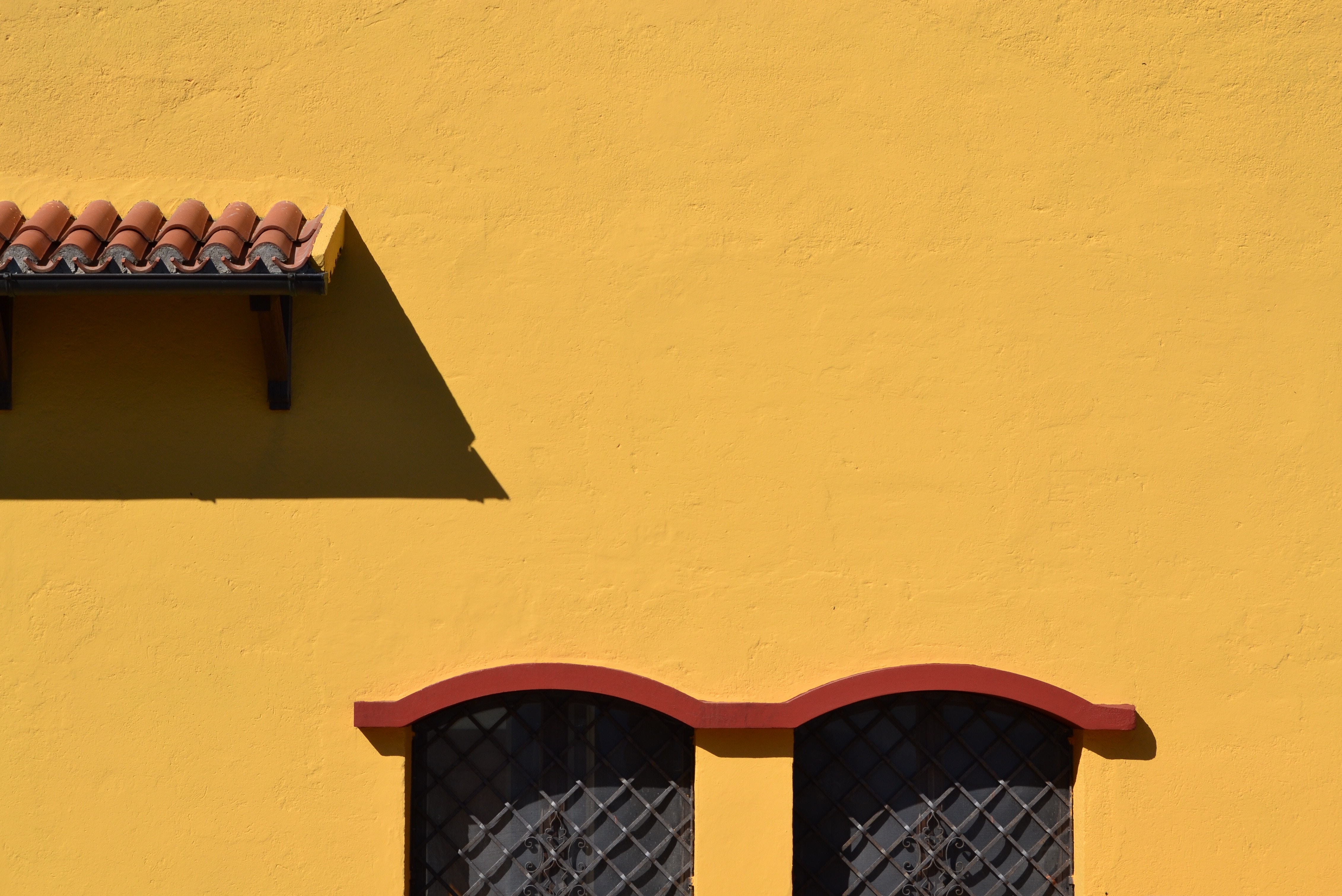 Yellow wall with tiled roof and windows HD Wallpaper