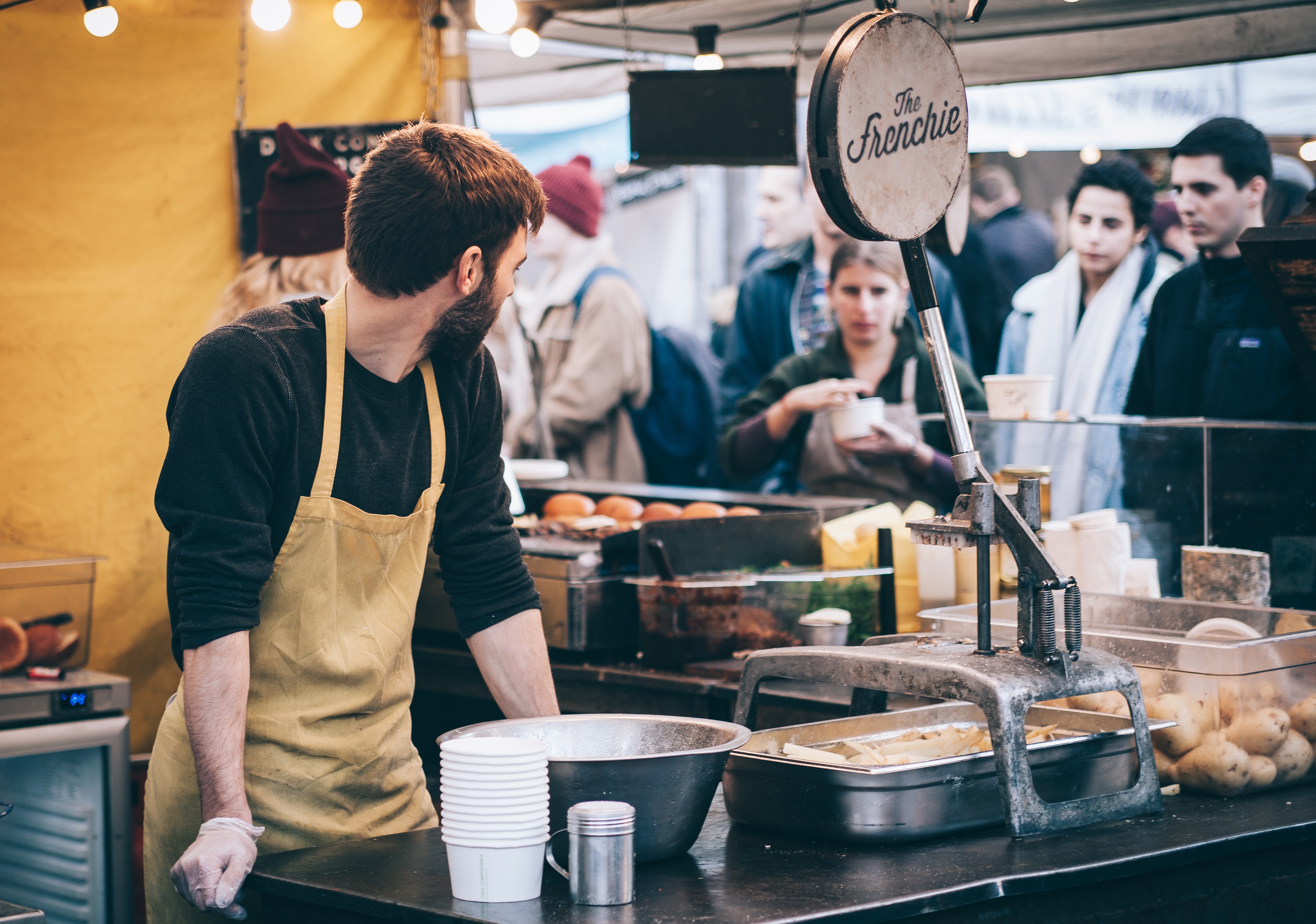 The Frenchie food stall with a chef serving customers HD Wallpaper