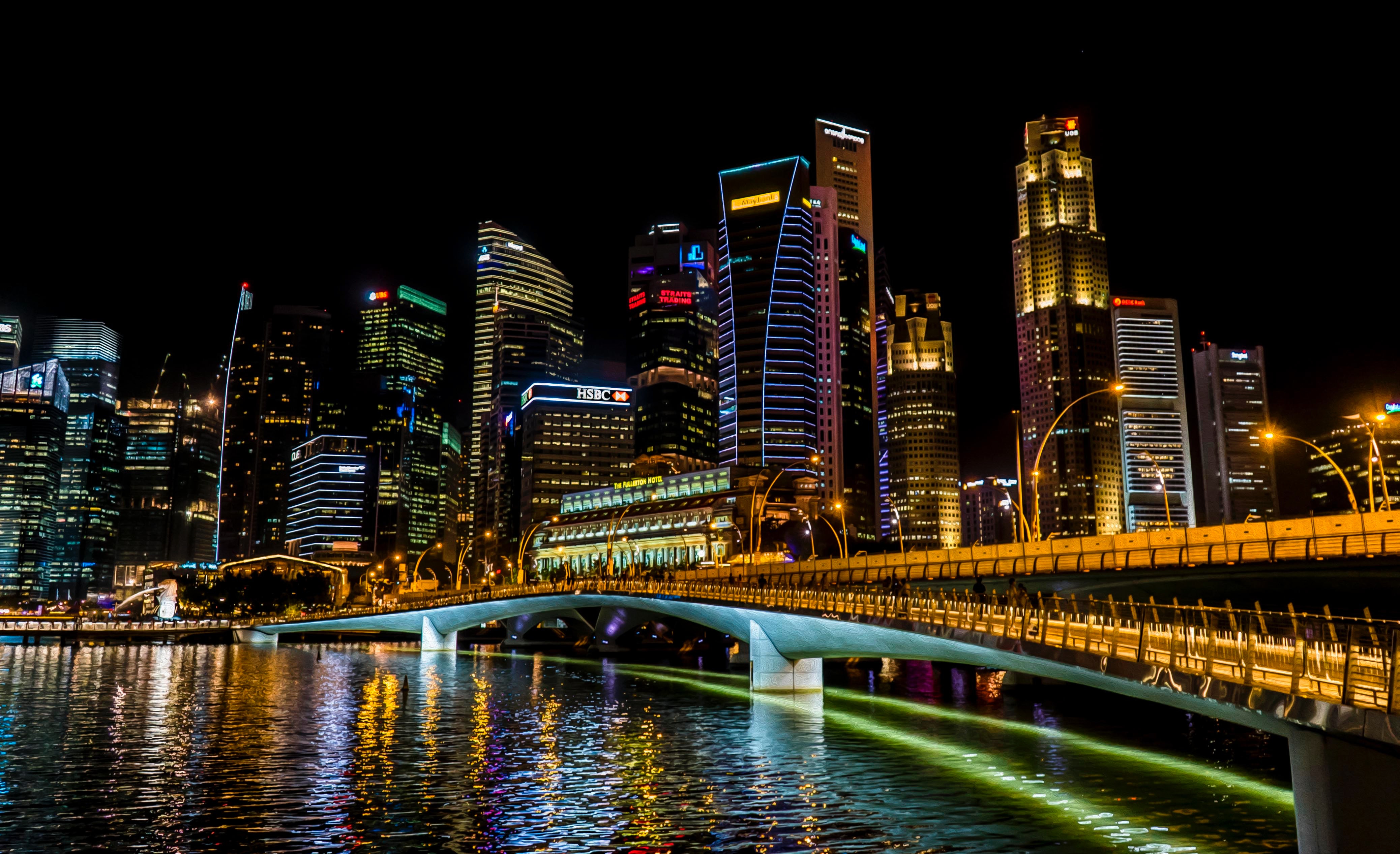 Singapore cityscape at night with illuminated skyscrapers and bridge HD Wallpaper