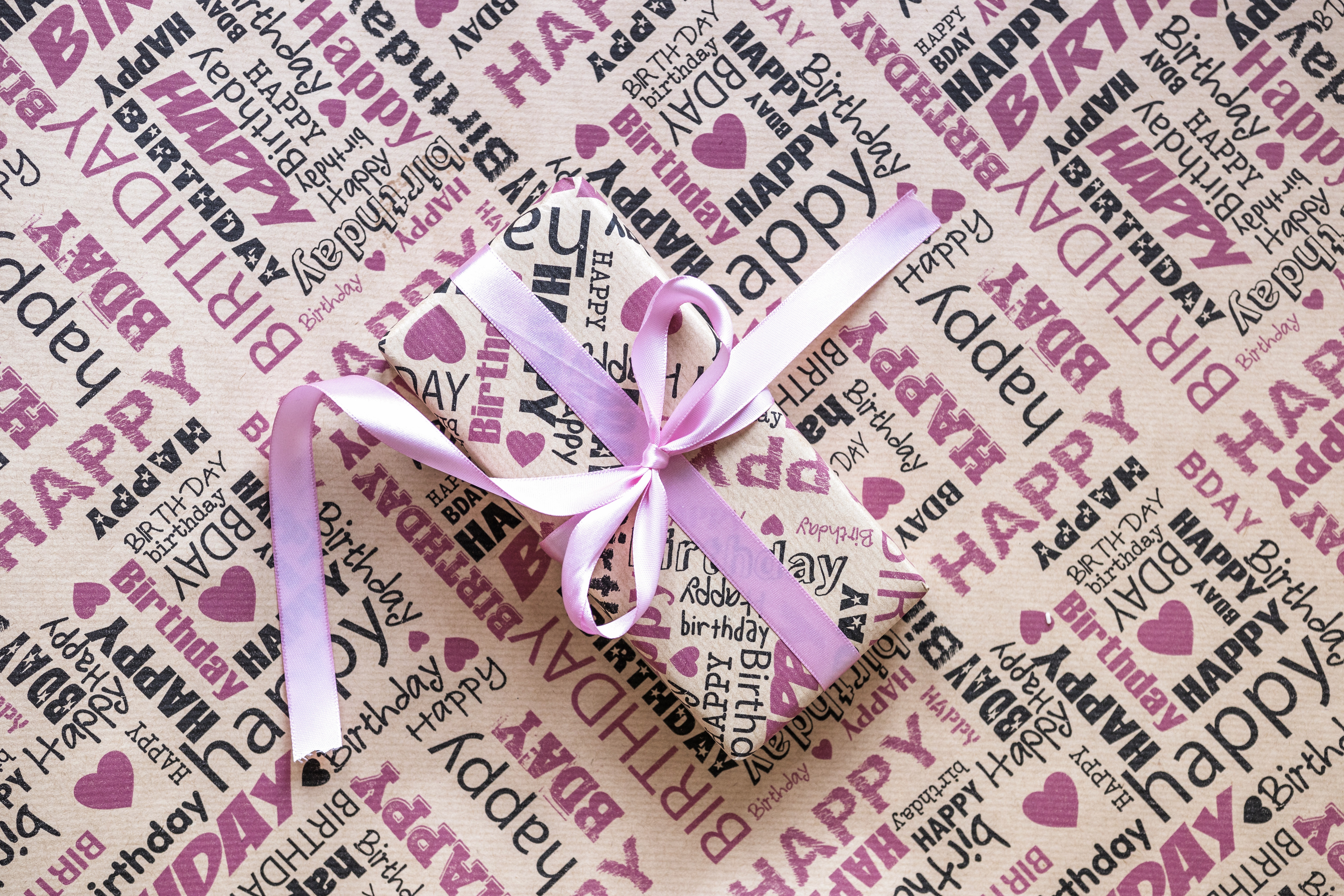 Birthday gift wrapped in patterned paper with ribbon HD Wallpaper