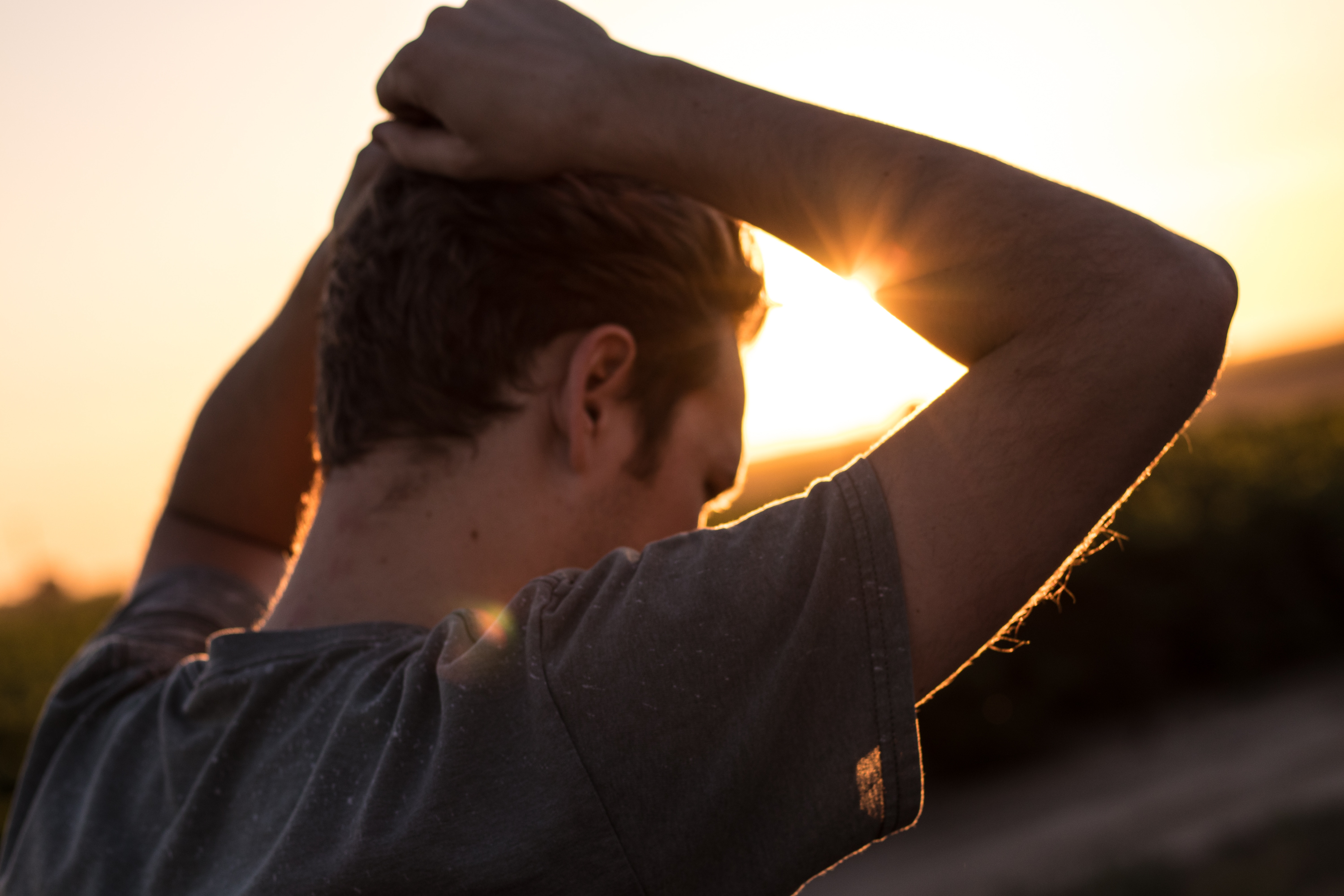 Man with hands up in golden hour sunset HD Wallpaper