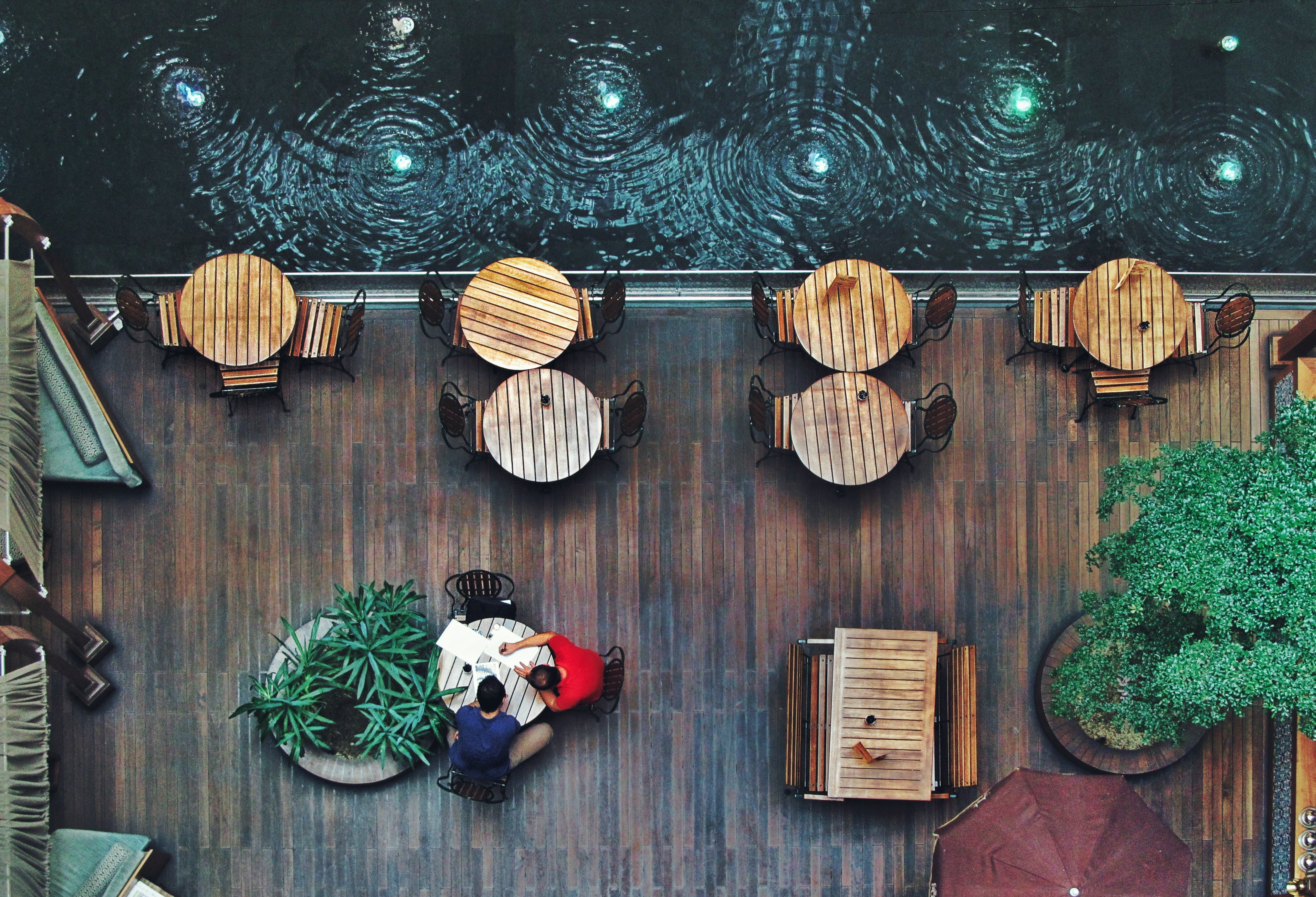 Aerial view of an outdoor cafe with tables and people HD Wallpaper