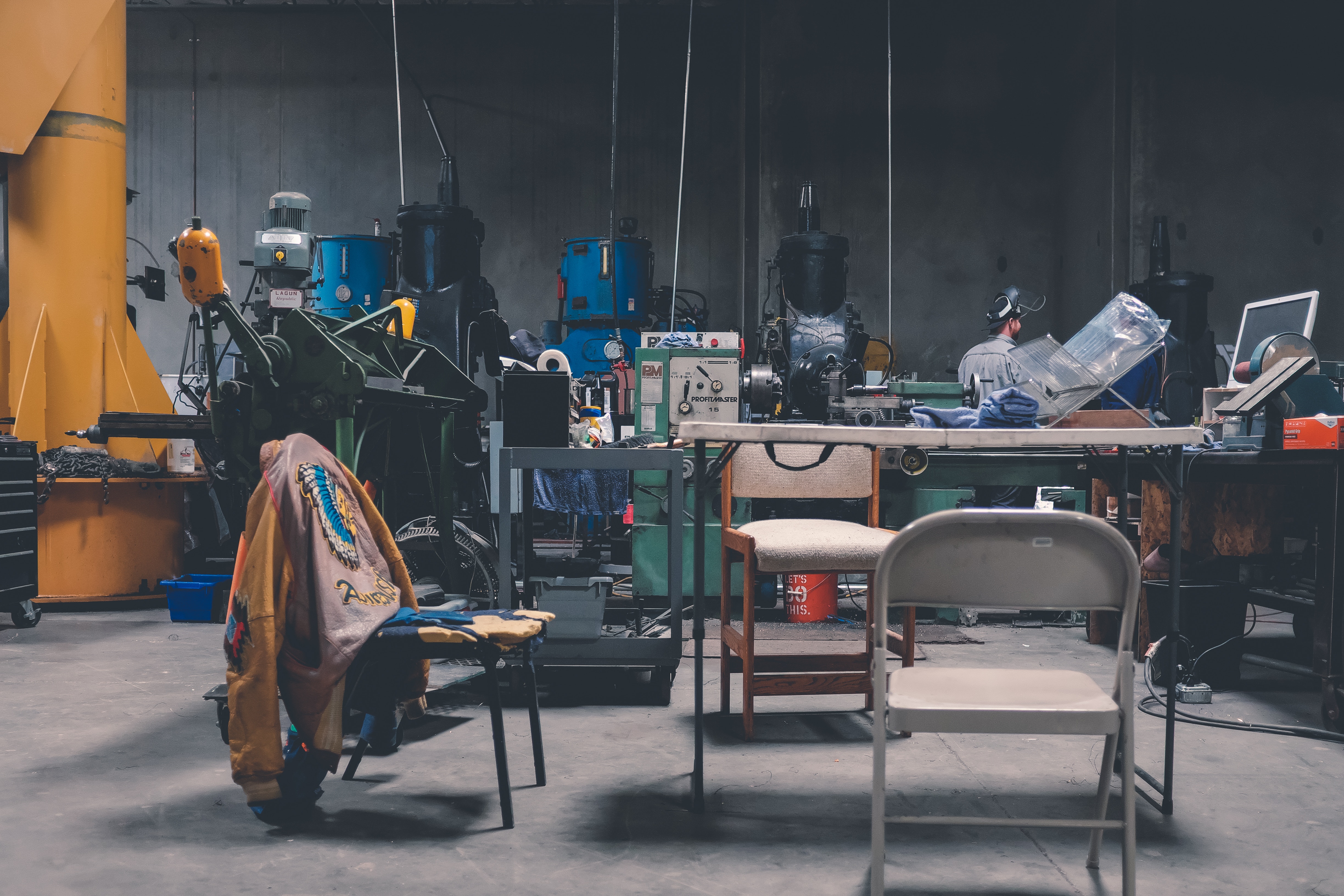 Workshop with machinery, chairs, and a jacket HD Wallpaper