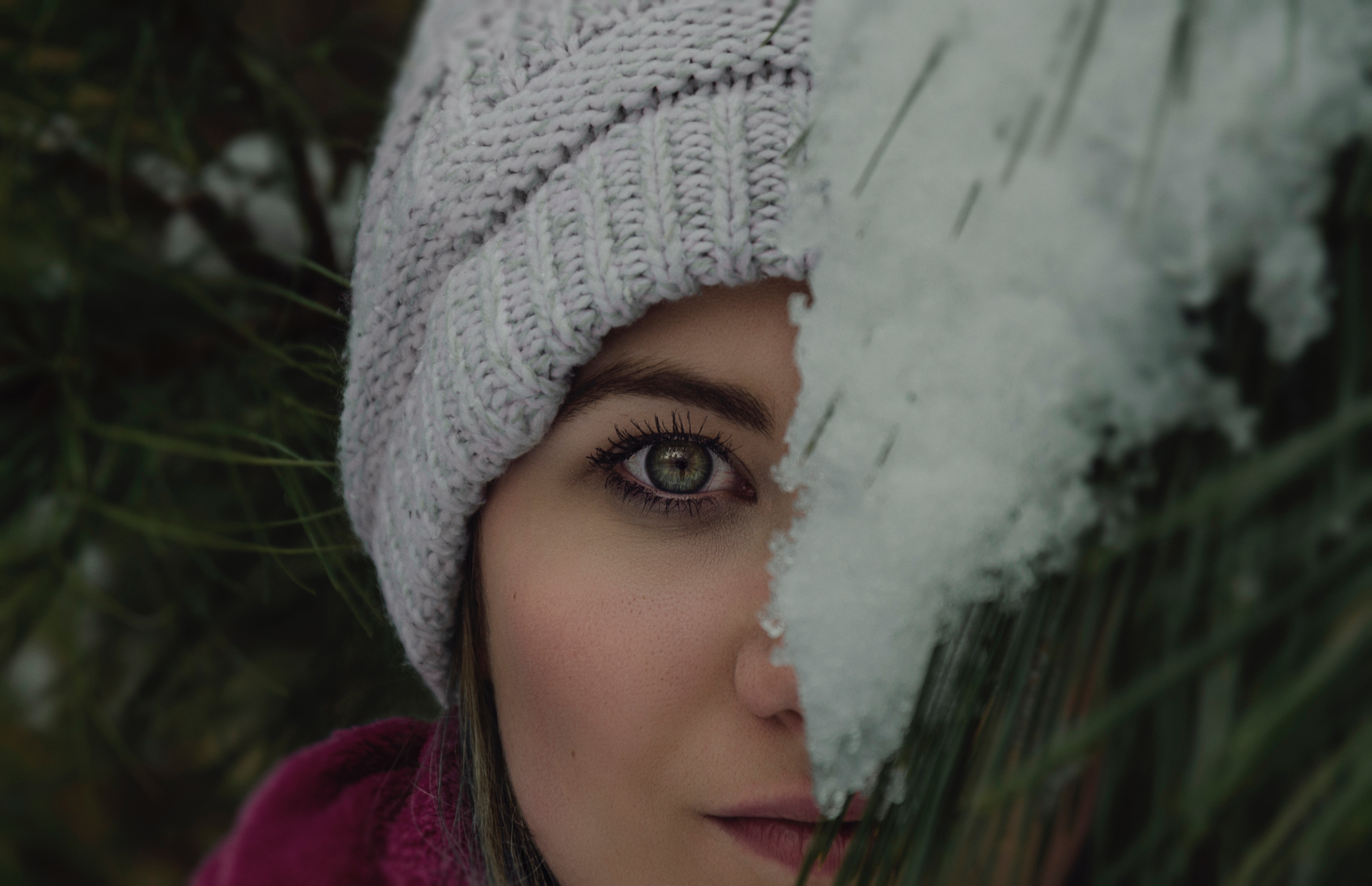 Woman in knitted cap with snow on pine needles HD Wallpaper