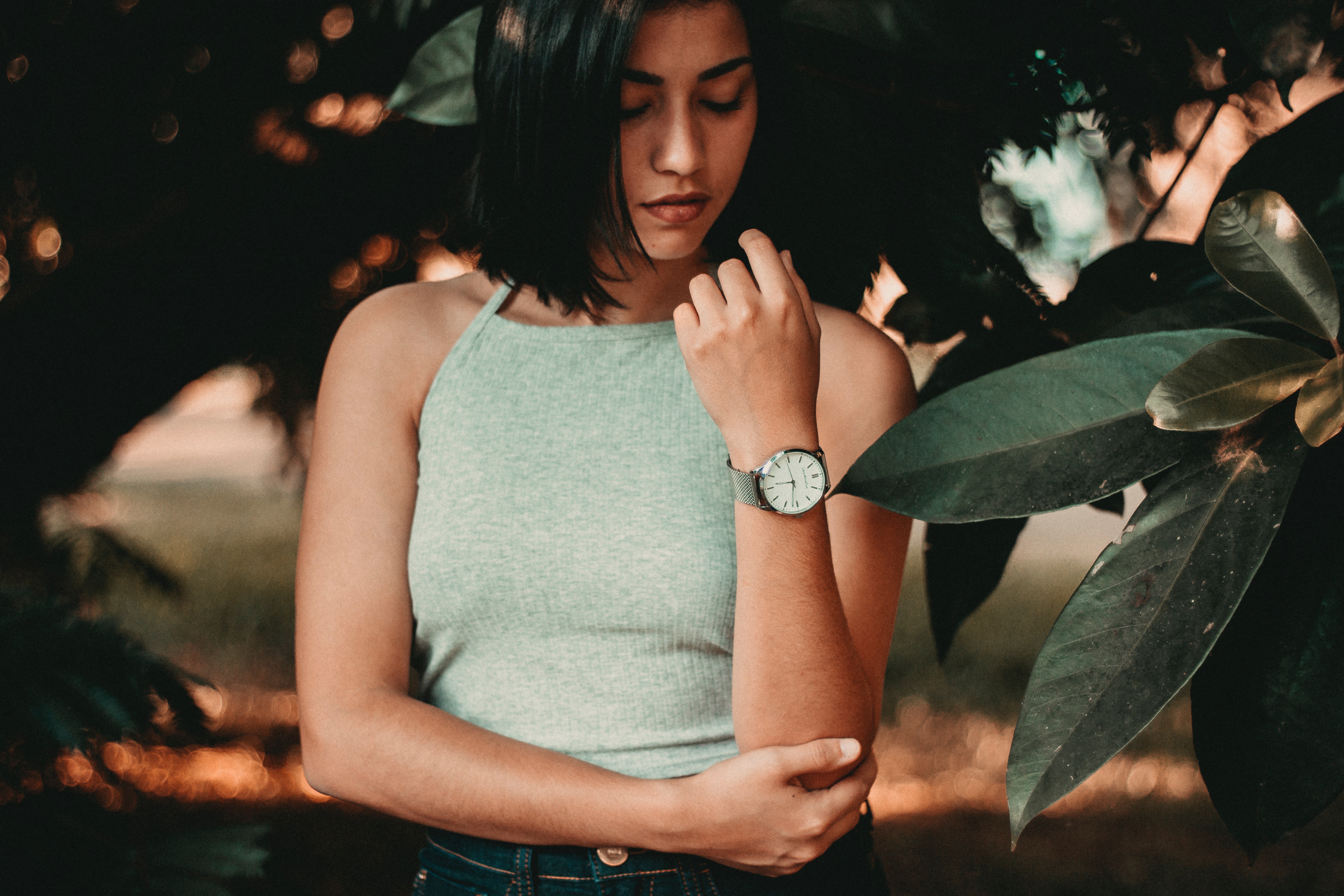 Woman wearing a watch among green leaves HD Wallpaper
