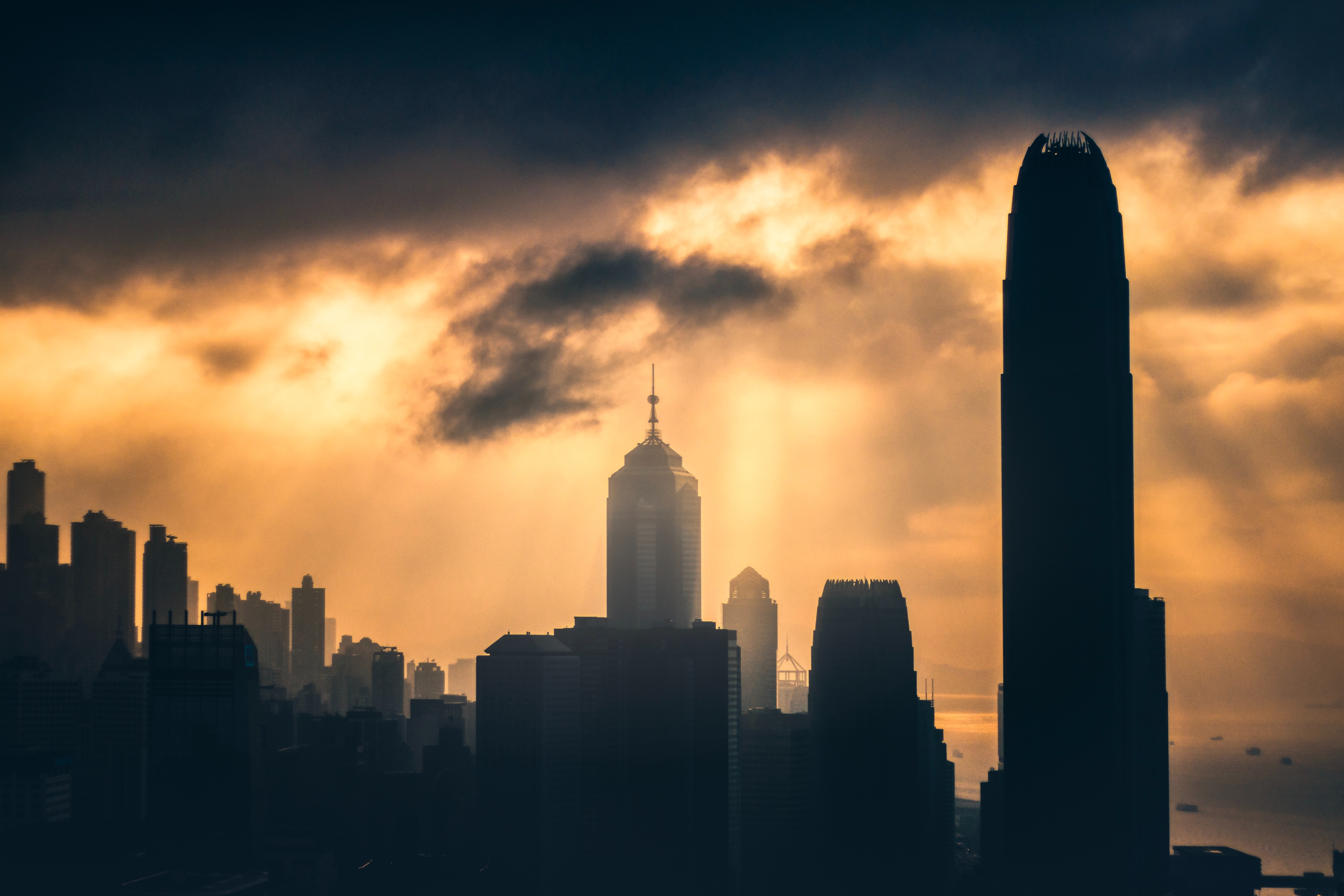 Cityscape with dramatic clouds and sunbeams HD Wallpaper