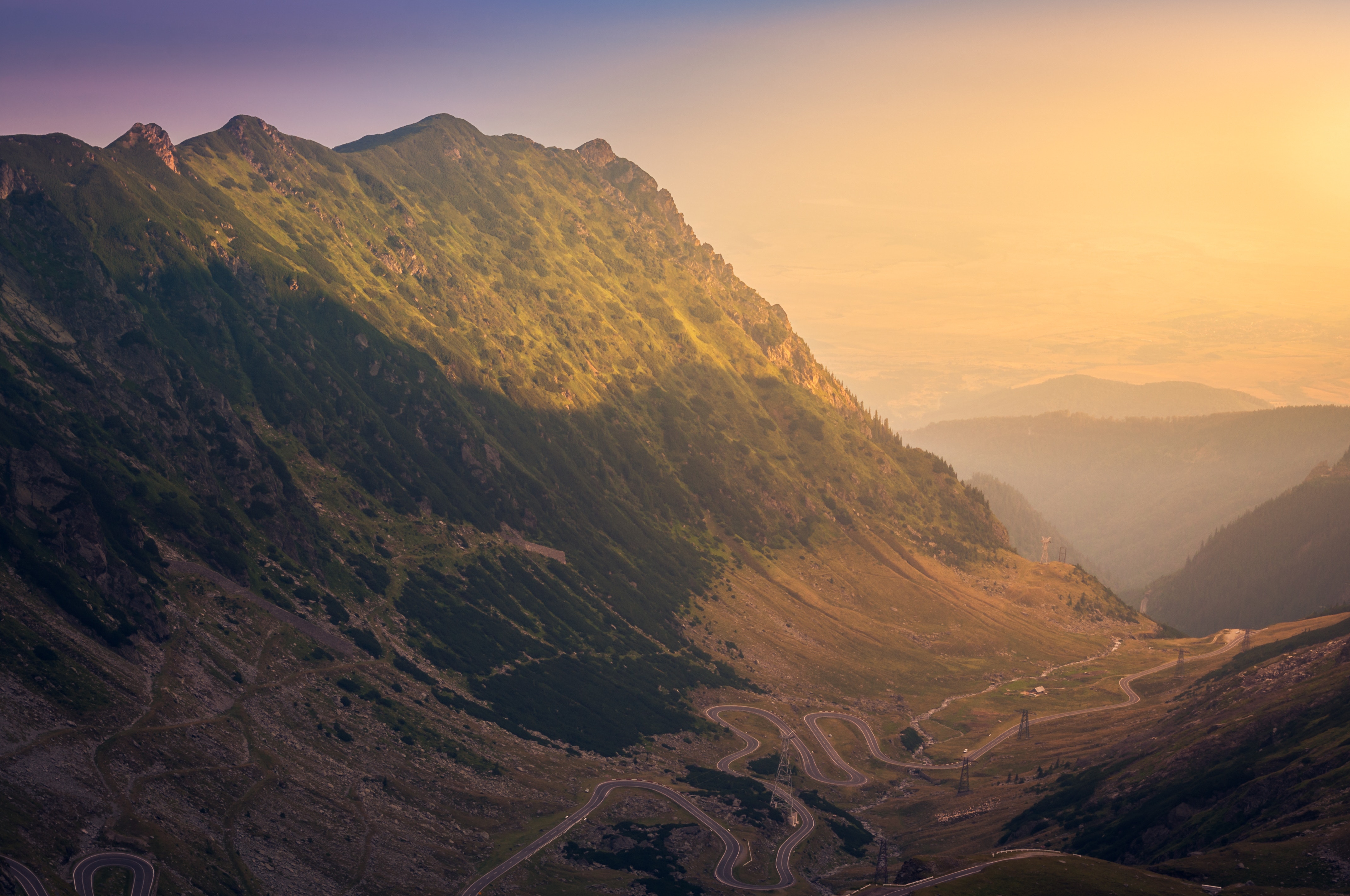 Mountain road at sunrise with haze HD Wallpaper