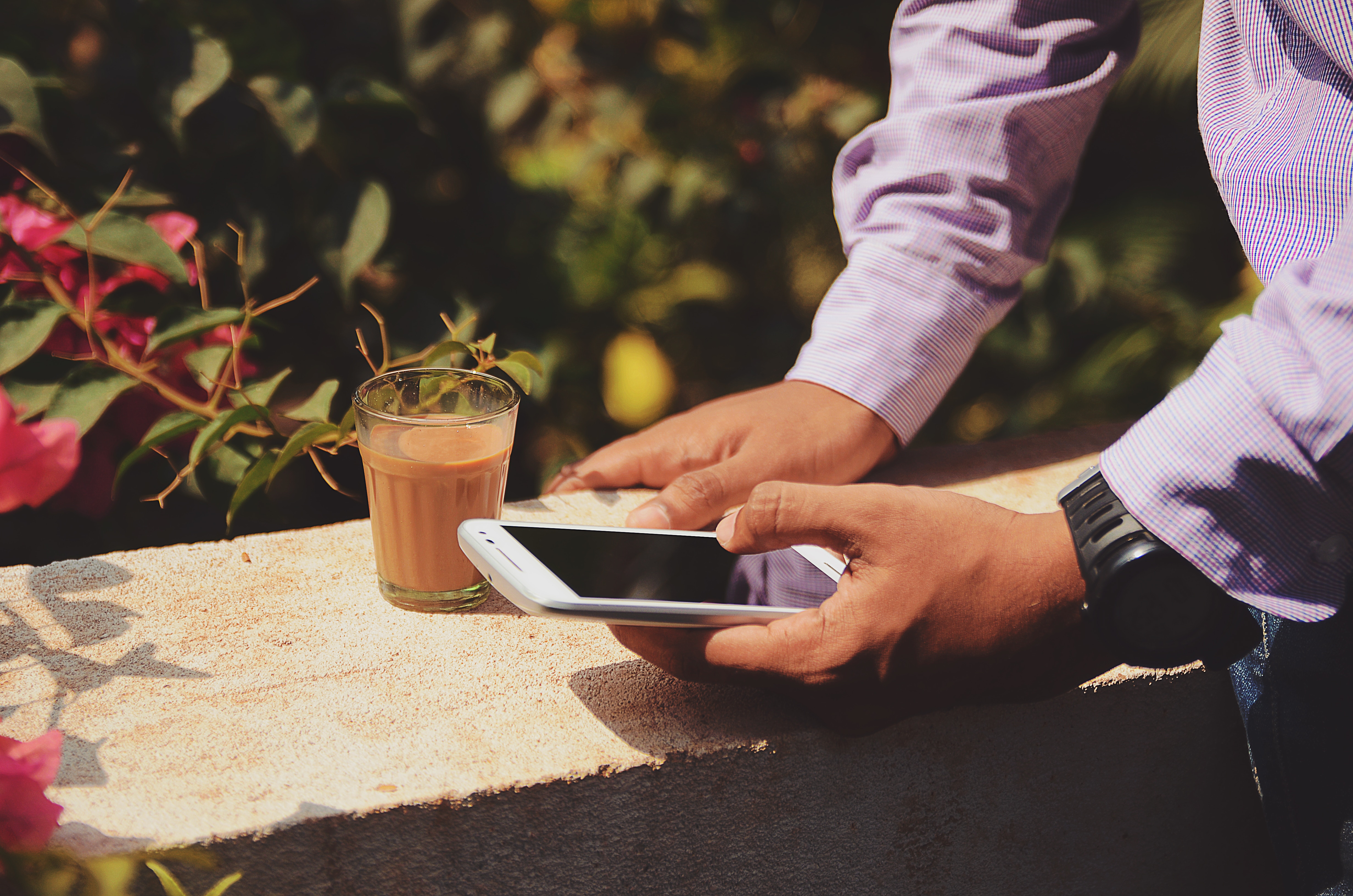 Man holding a smartphone and a glass of tea HD Wallpaper