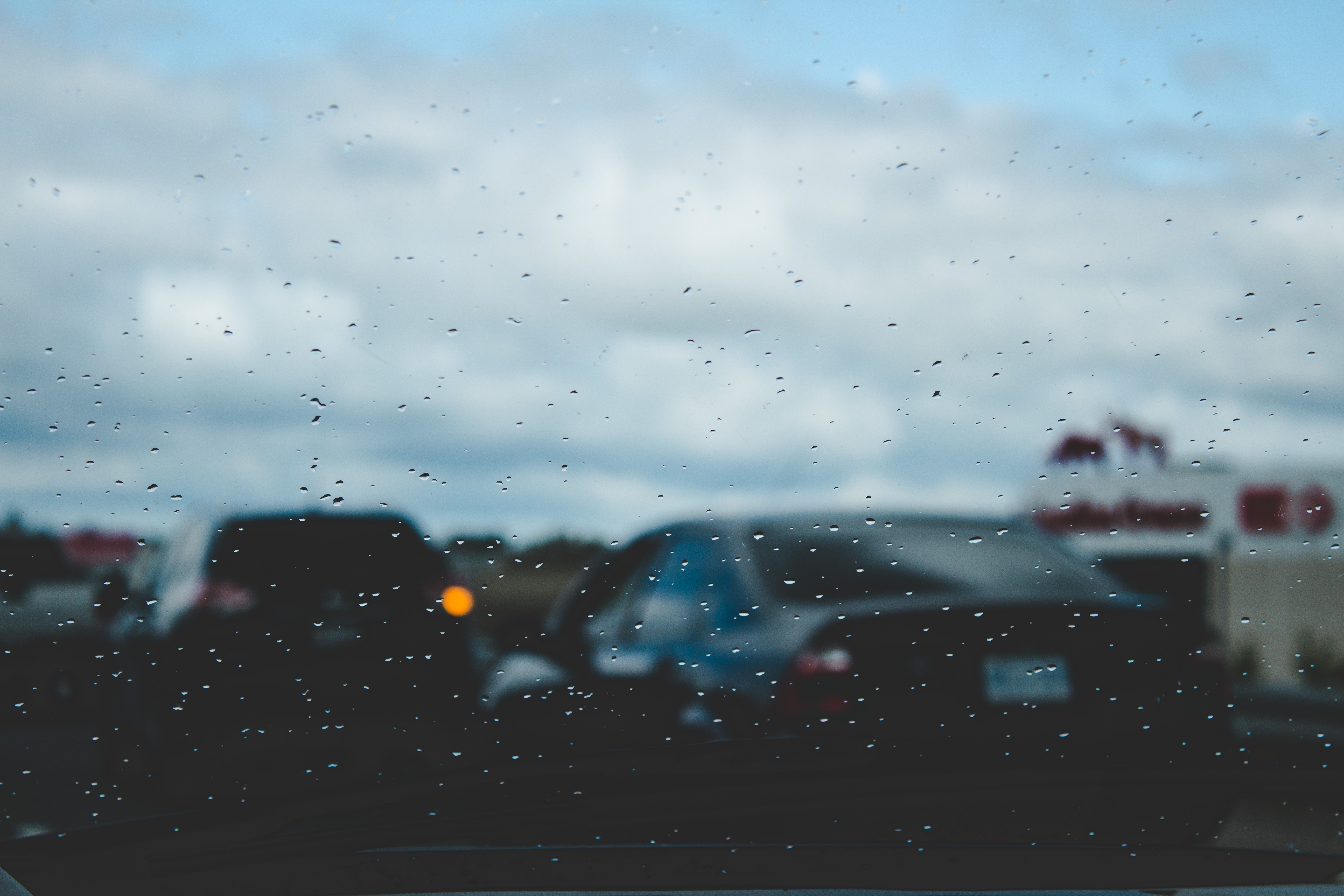Cars on a rainy day with a building in the background HD Wallpaper