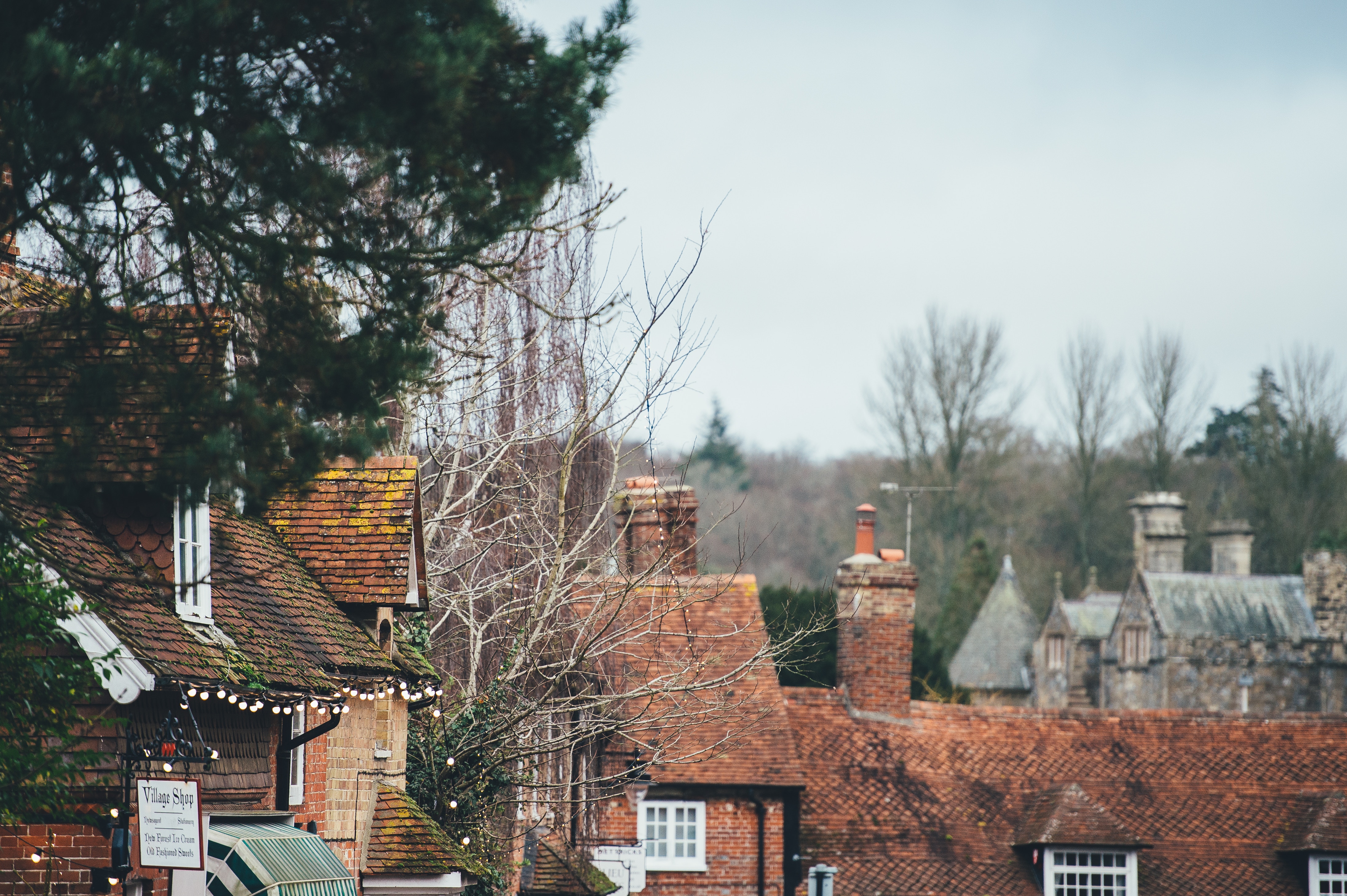 Village shop with tiled roofs and chimneys HD Wallpaper