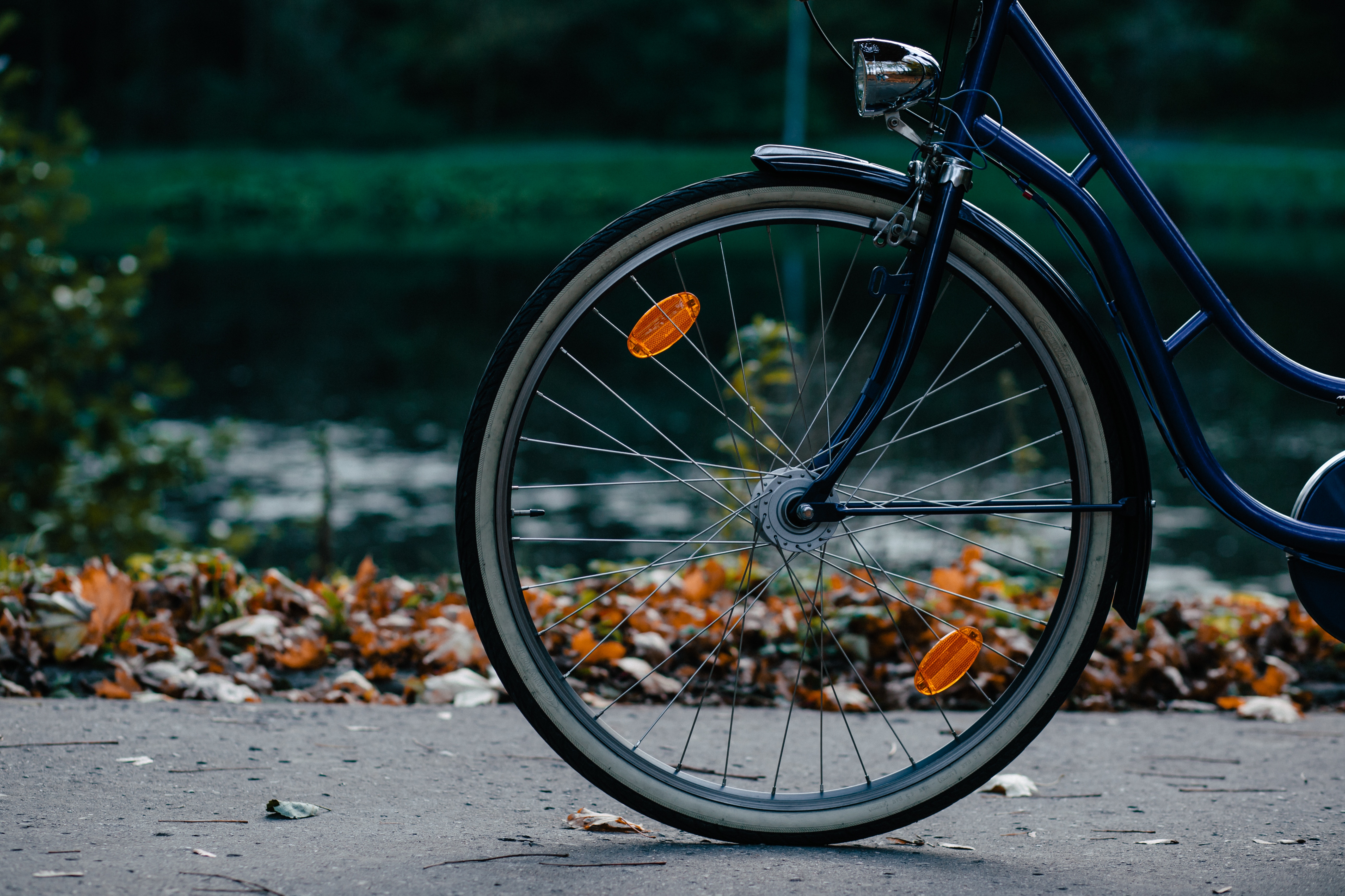 Bicycle wheel with orange reflectors and bike light HD Wallpaper