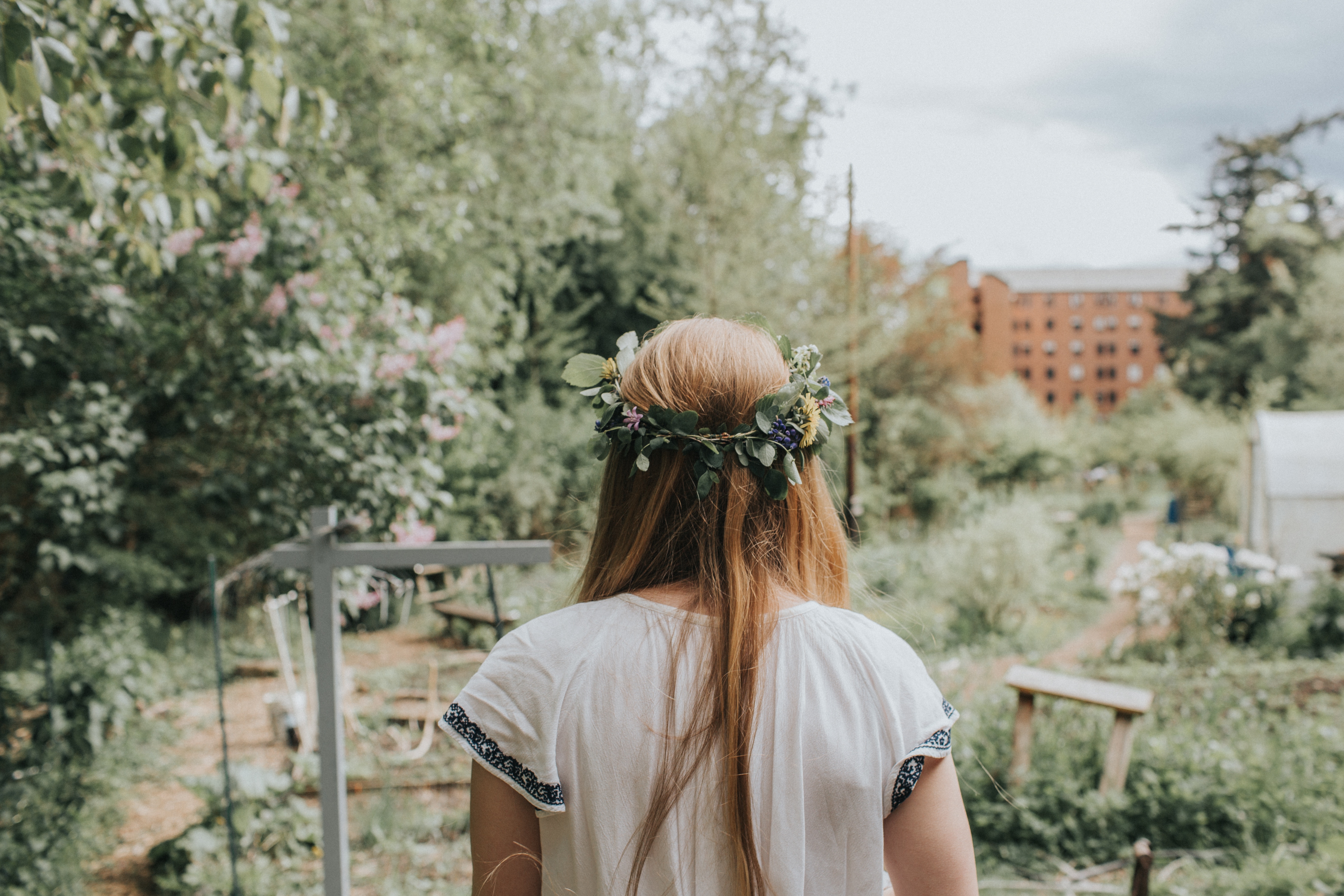 Woman with flower crown in a garden HD Wallpaper