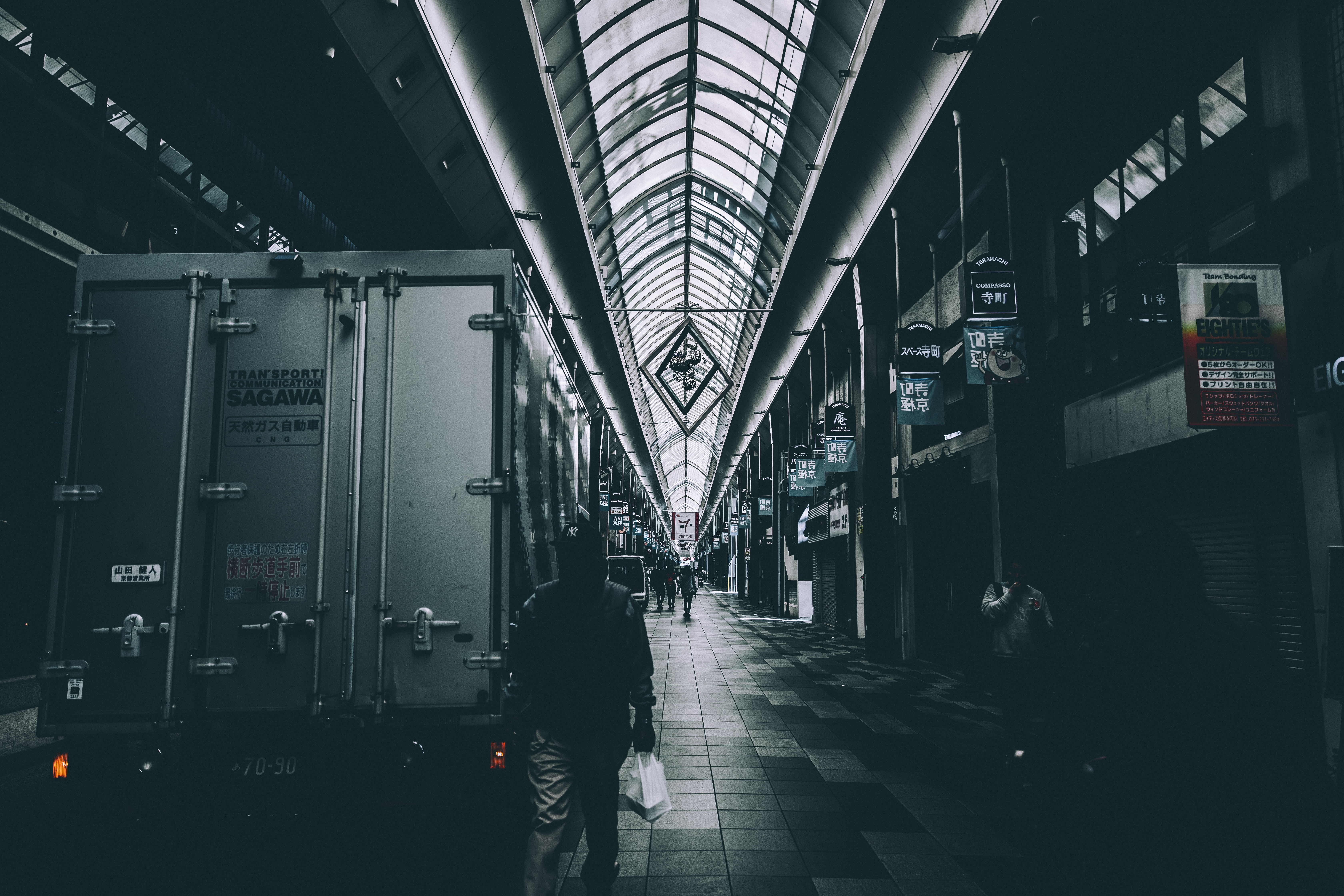 Man walking in a dark urban hallway with a truck HD Wallpaper