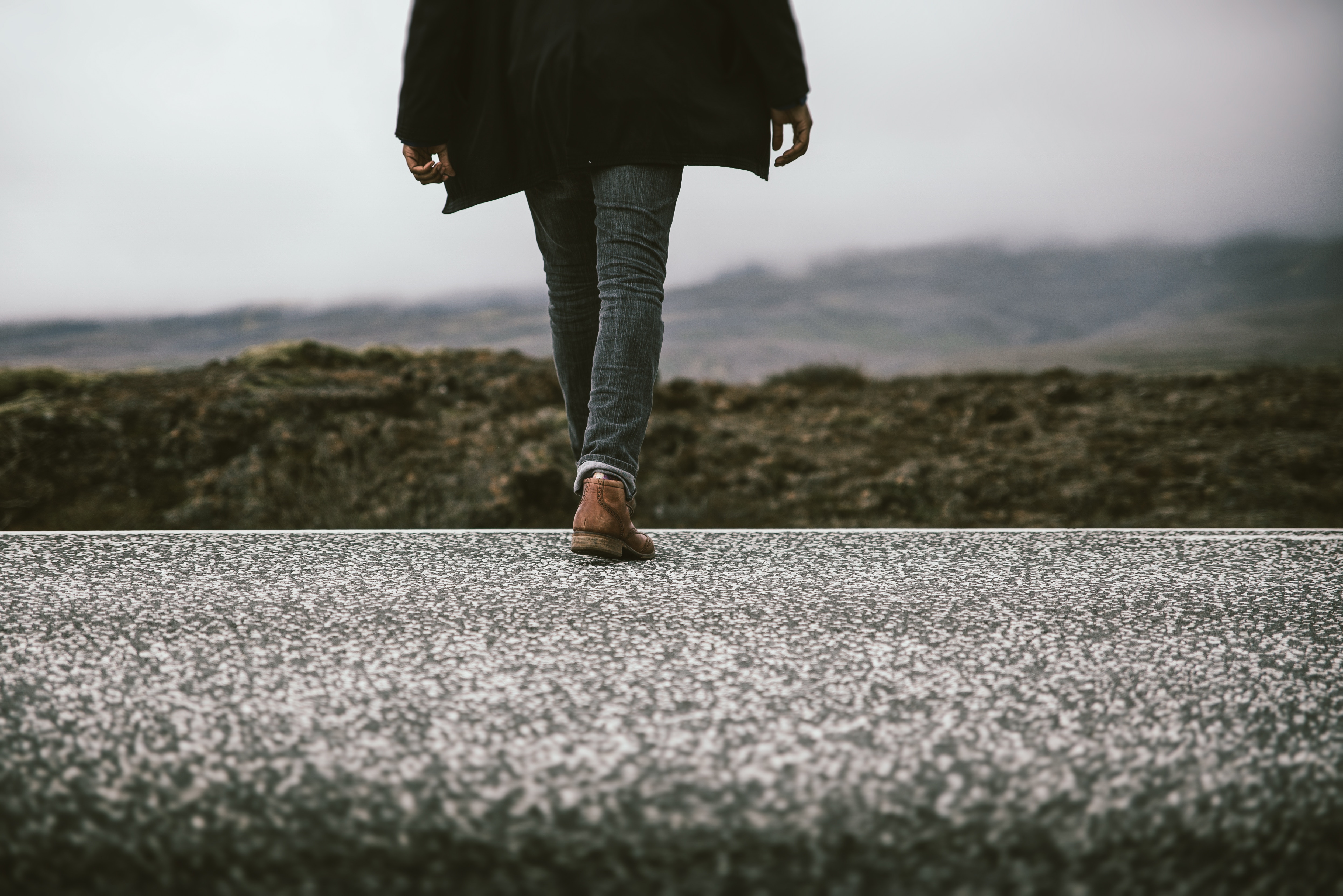 Person walking on a textured path with a misty landscape HD Wallpaper