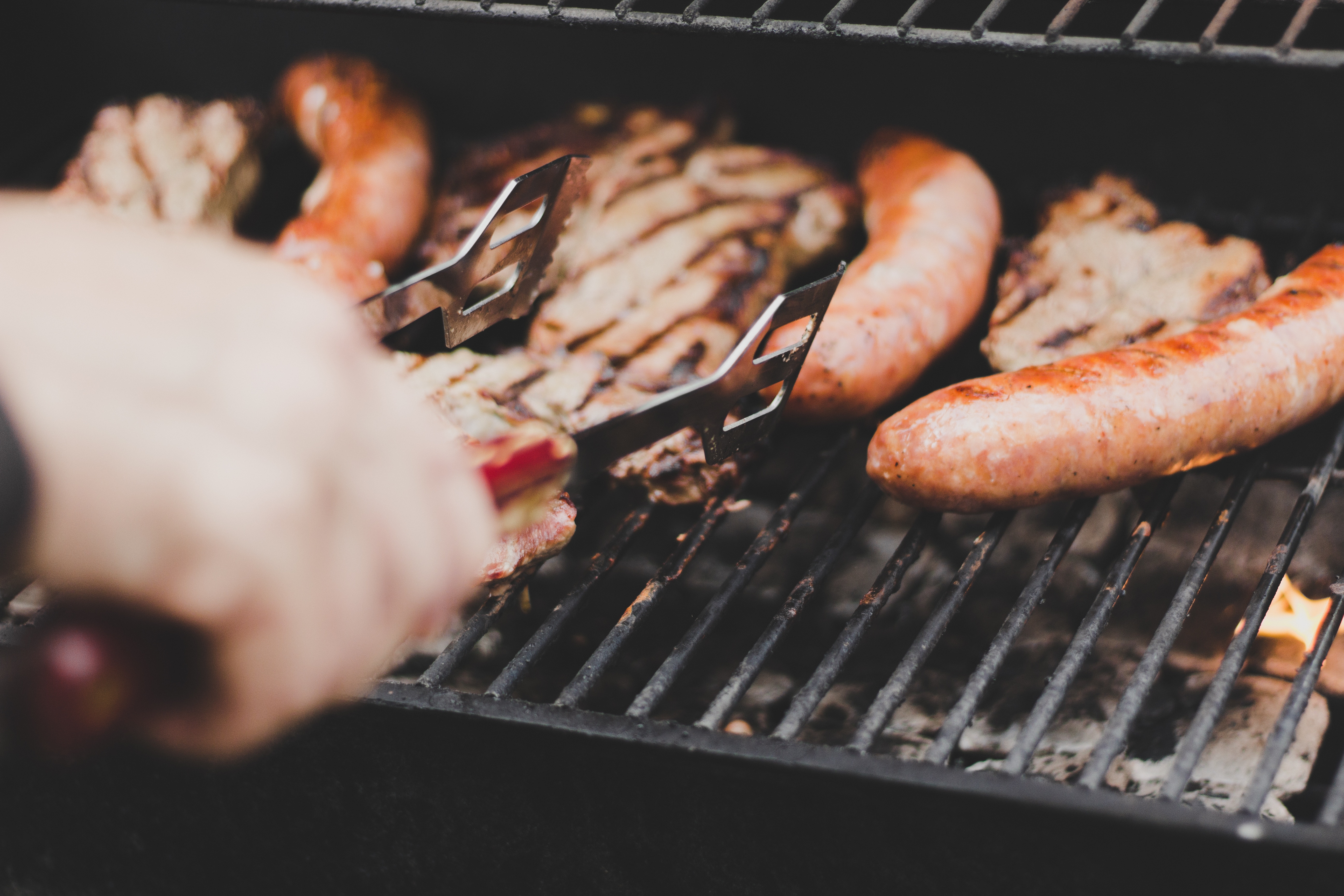 Sausages and meat cooking on a barbecue grill HD Wallpaper