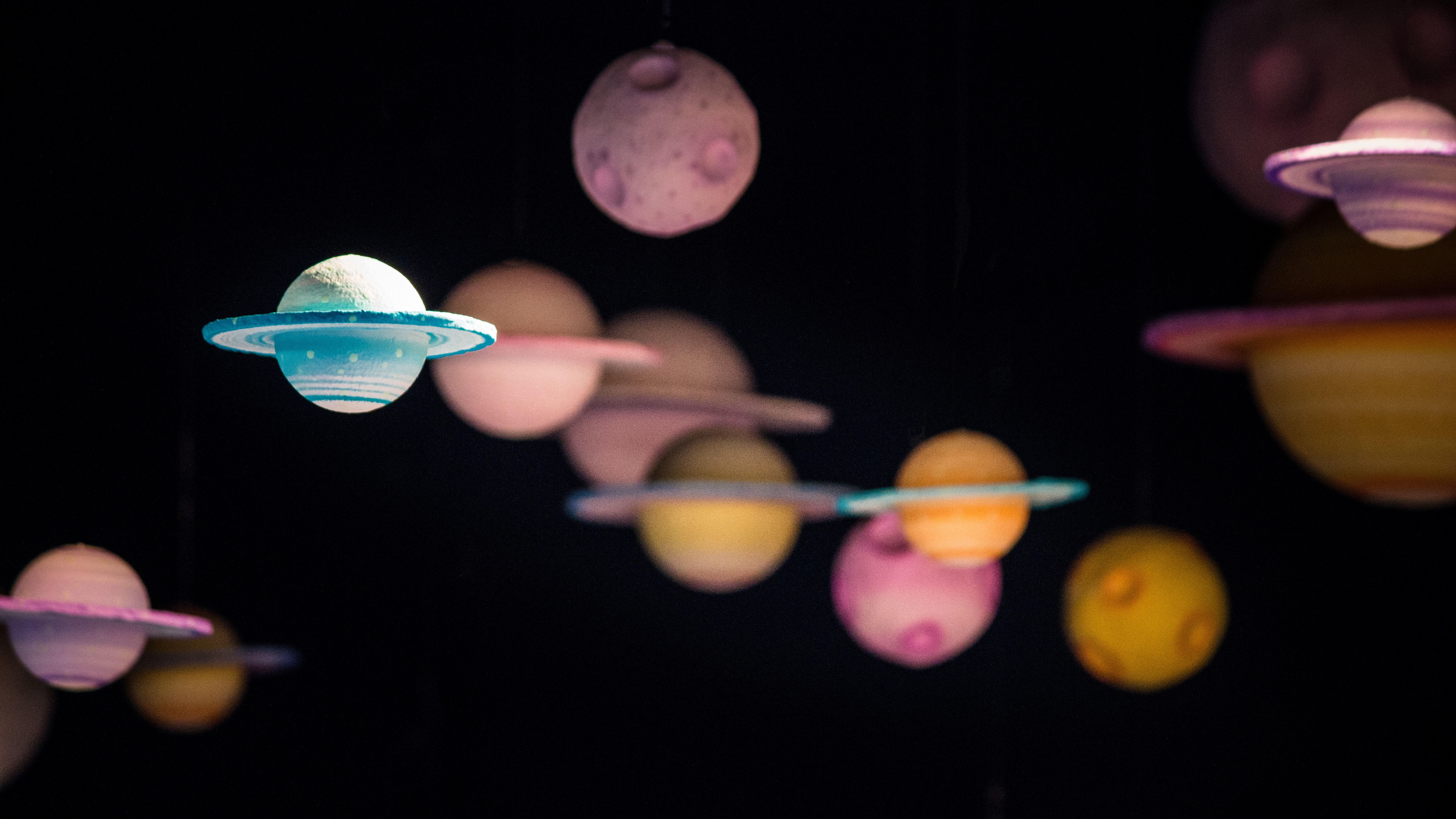 Model planets hanging in a dark room HD Wallpaper