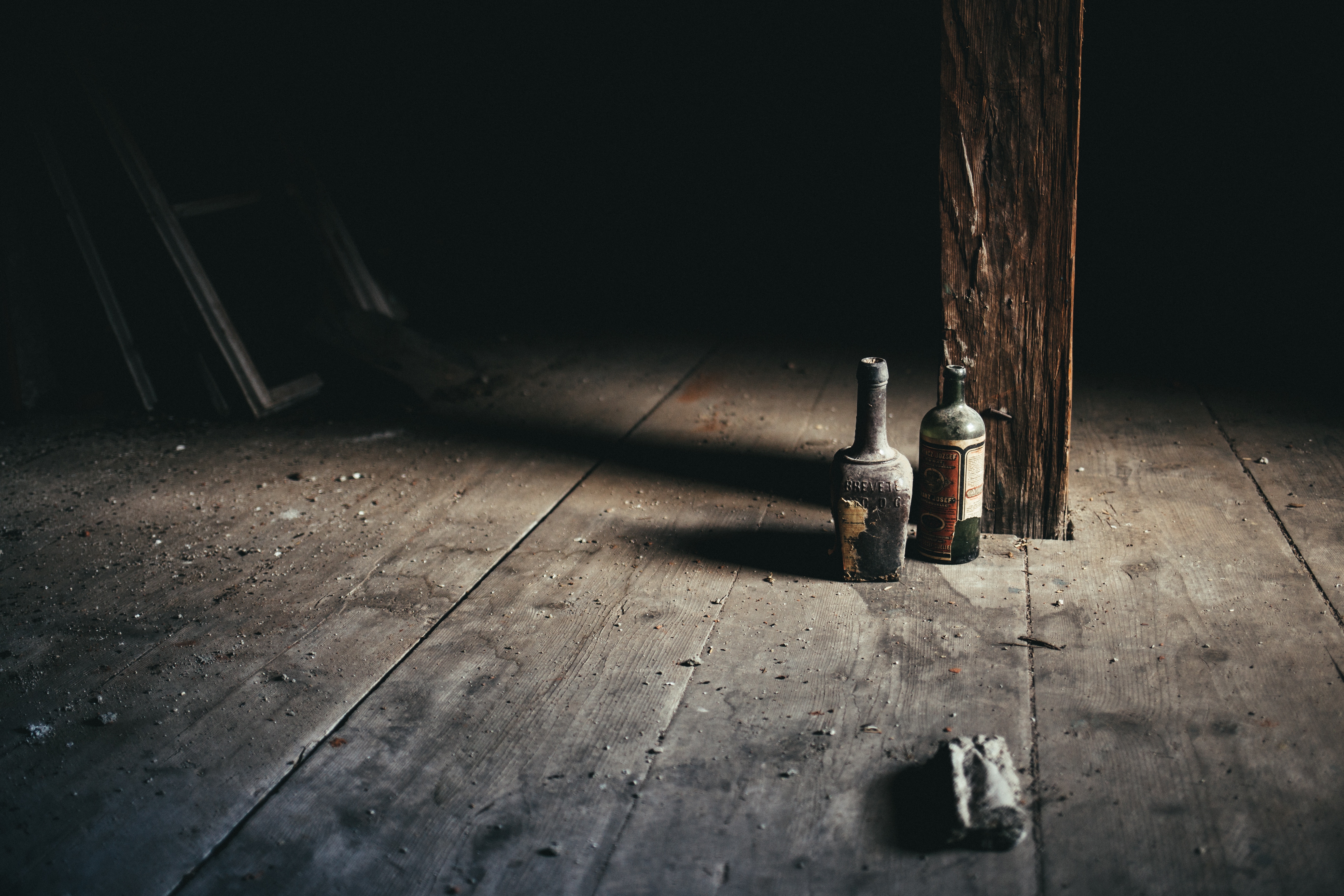 Two old bottles on a dusty wooden floor HD Wallpaper