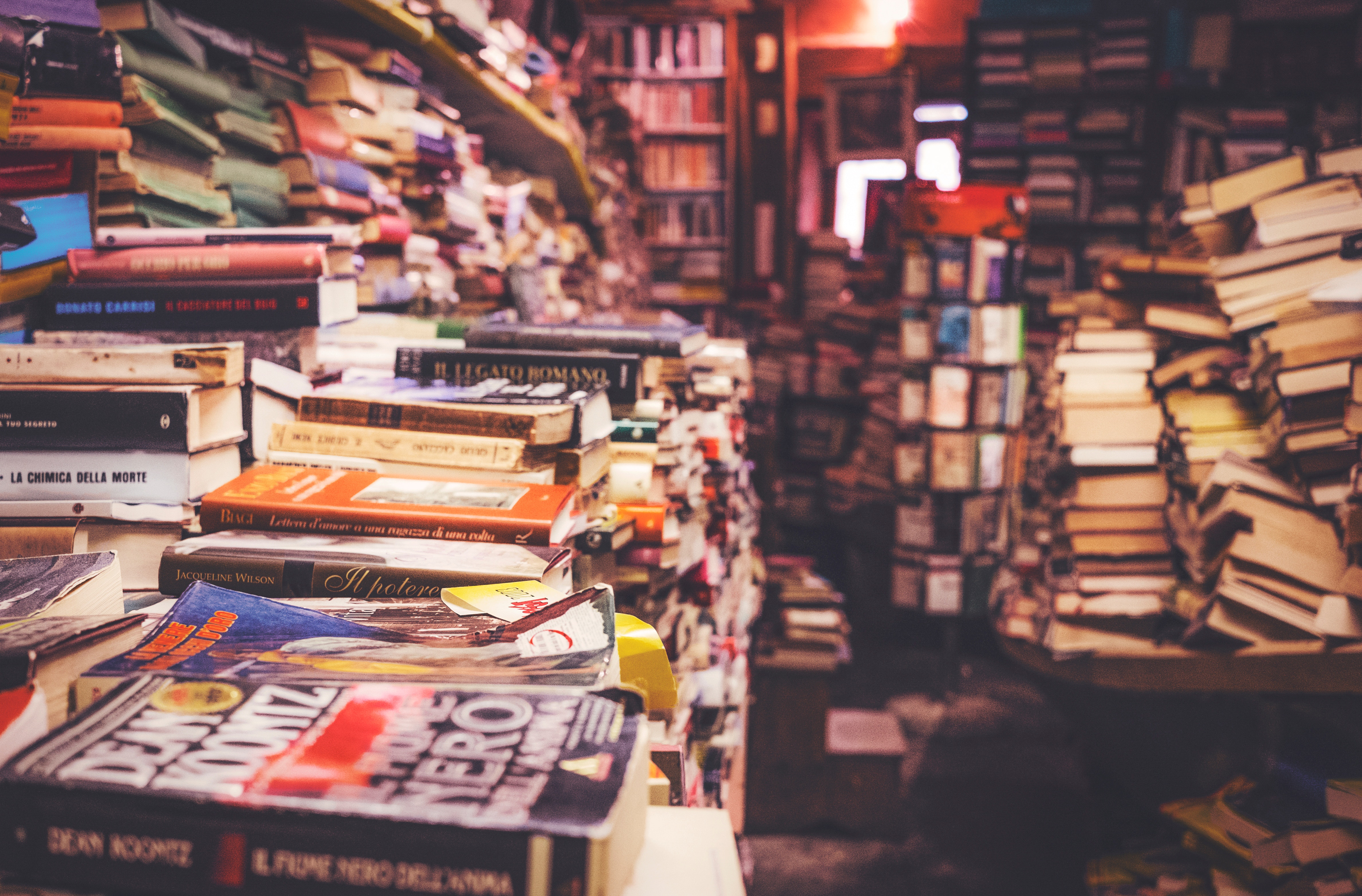 Stacks of books in a cluttered bookstore HD Wallpaper