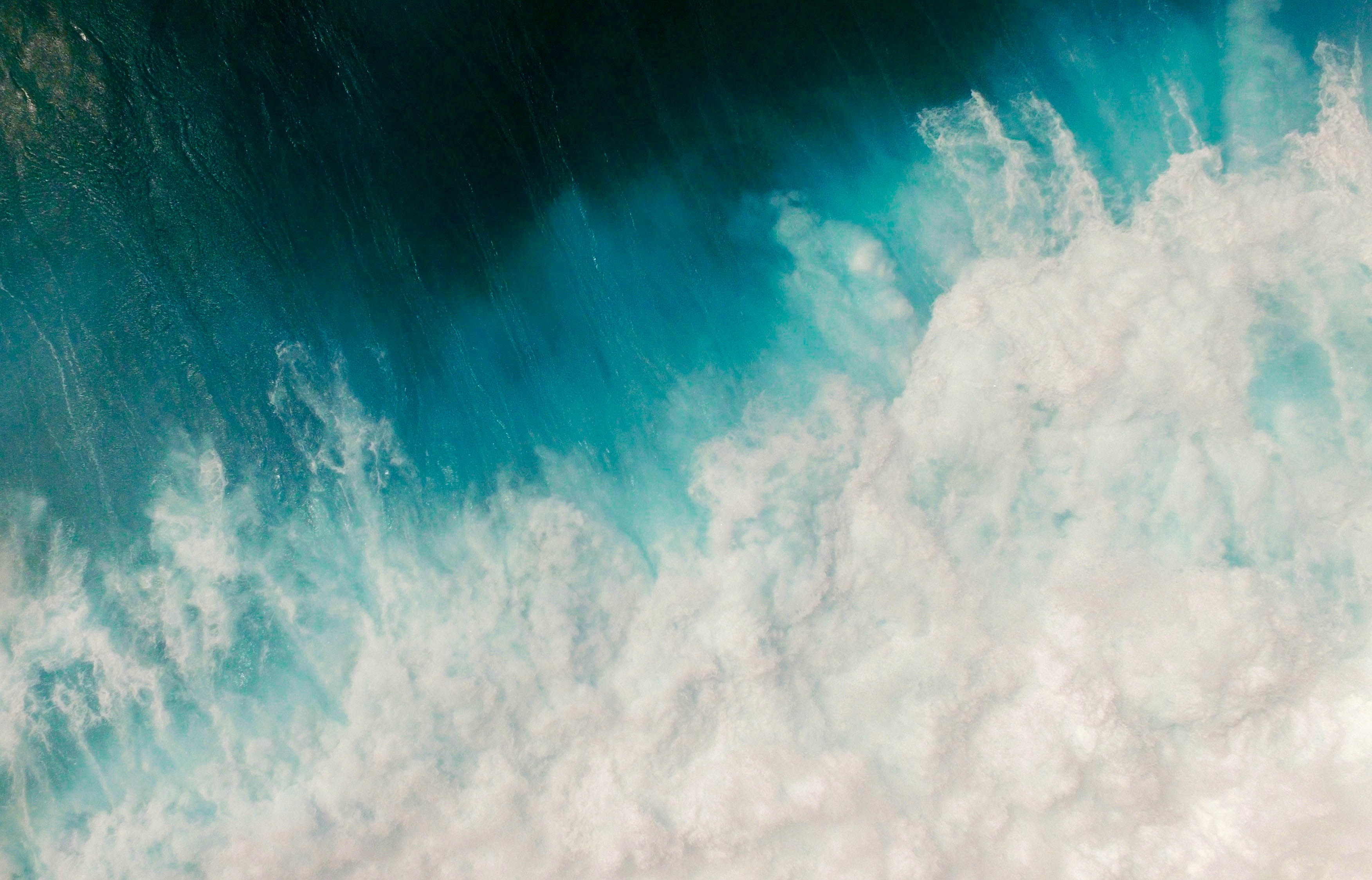 Aerial view of turquoise ocean wave with white foam HD Wallpaper