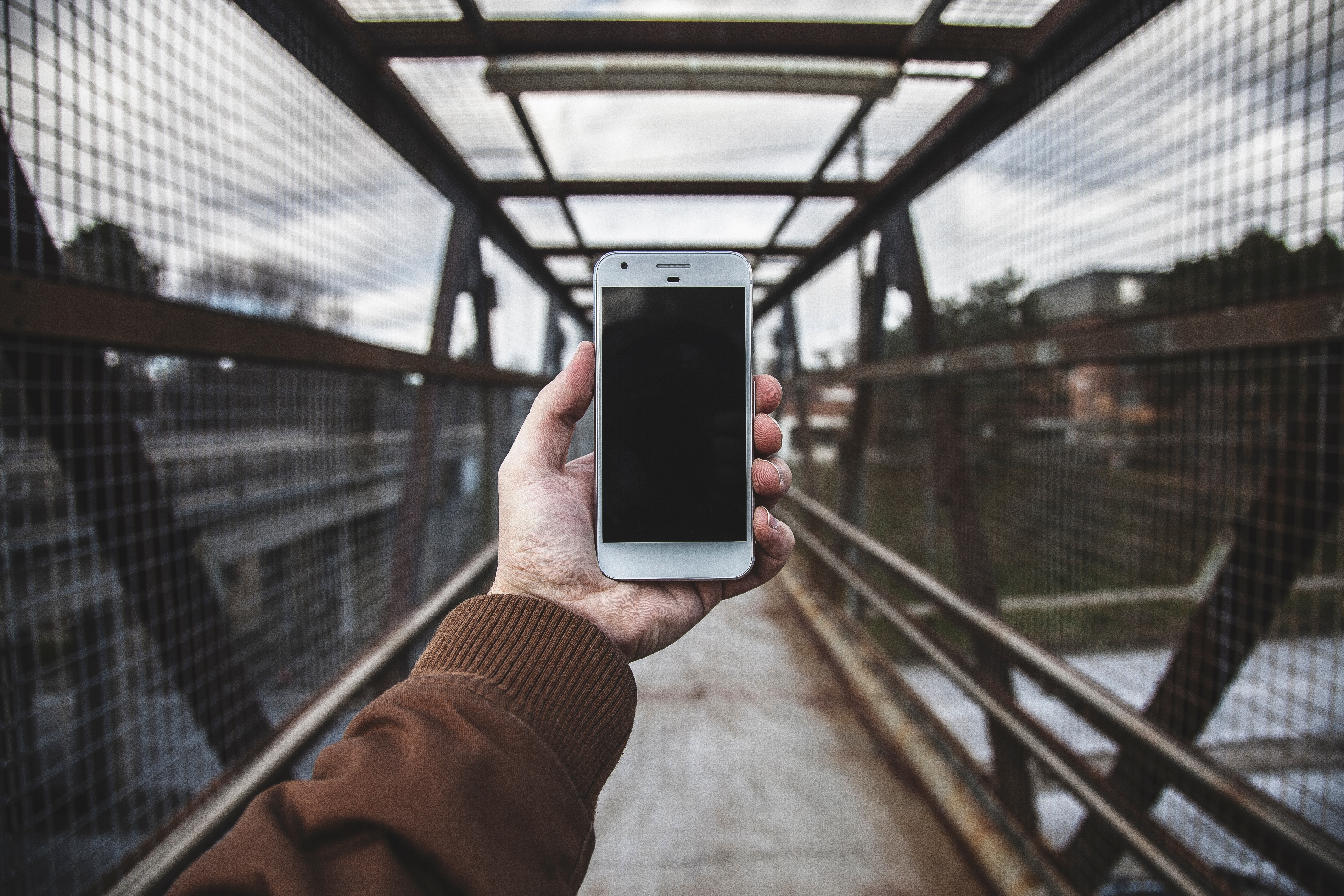 Man holding Google Pixel phone on a bridge HD Wallpaper