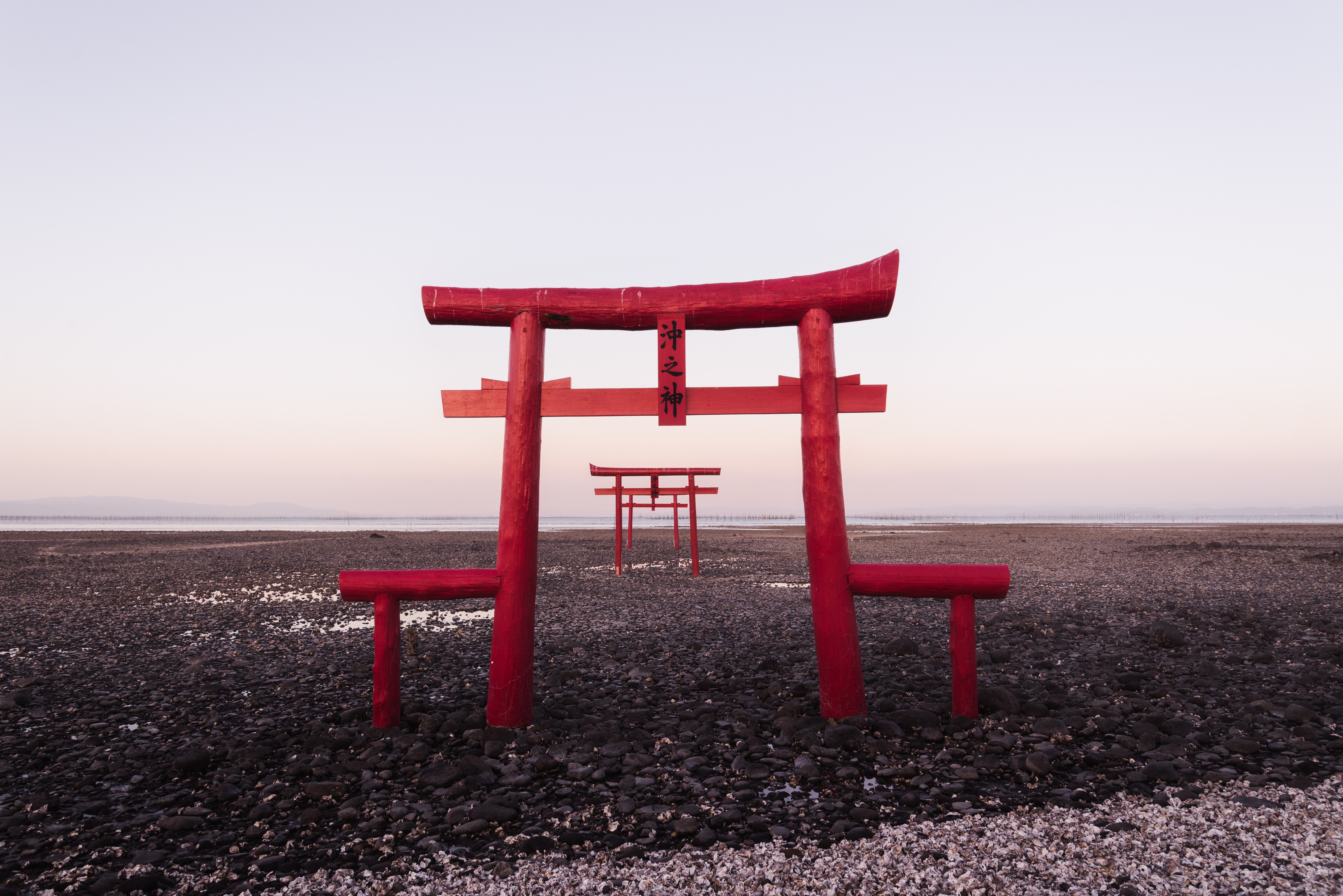 Red Torii Gates on a Rocky Beach at Sunrise HD Wallpaper