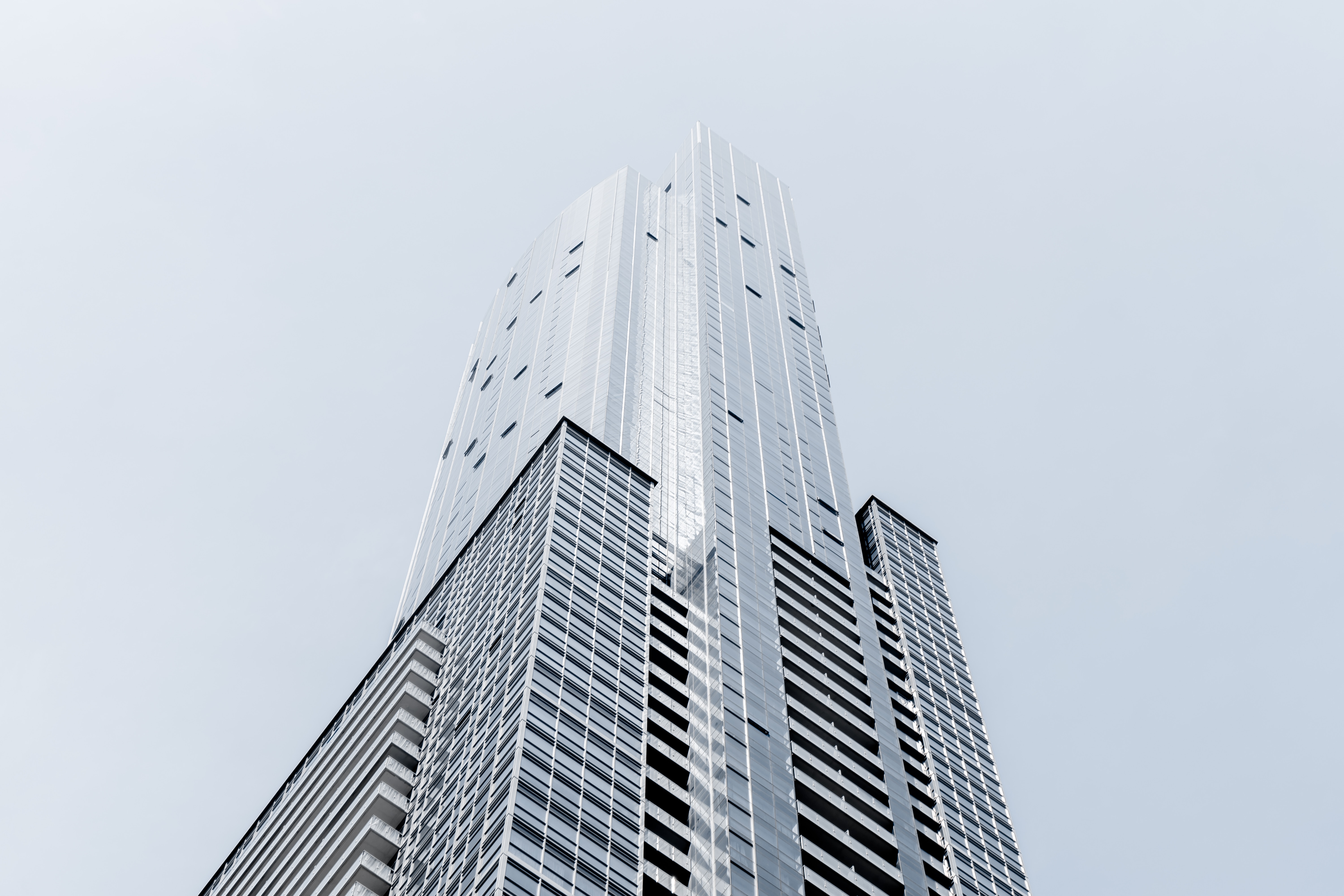 Modern skyscraper against a pale sky HD Wallpaper