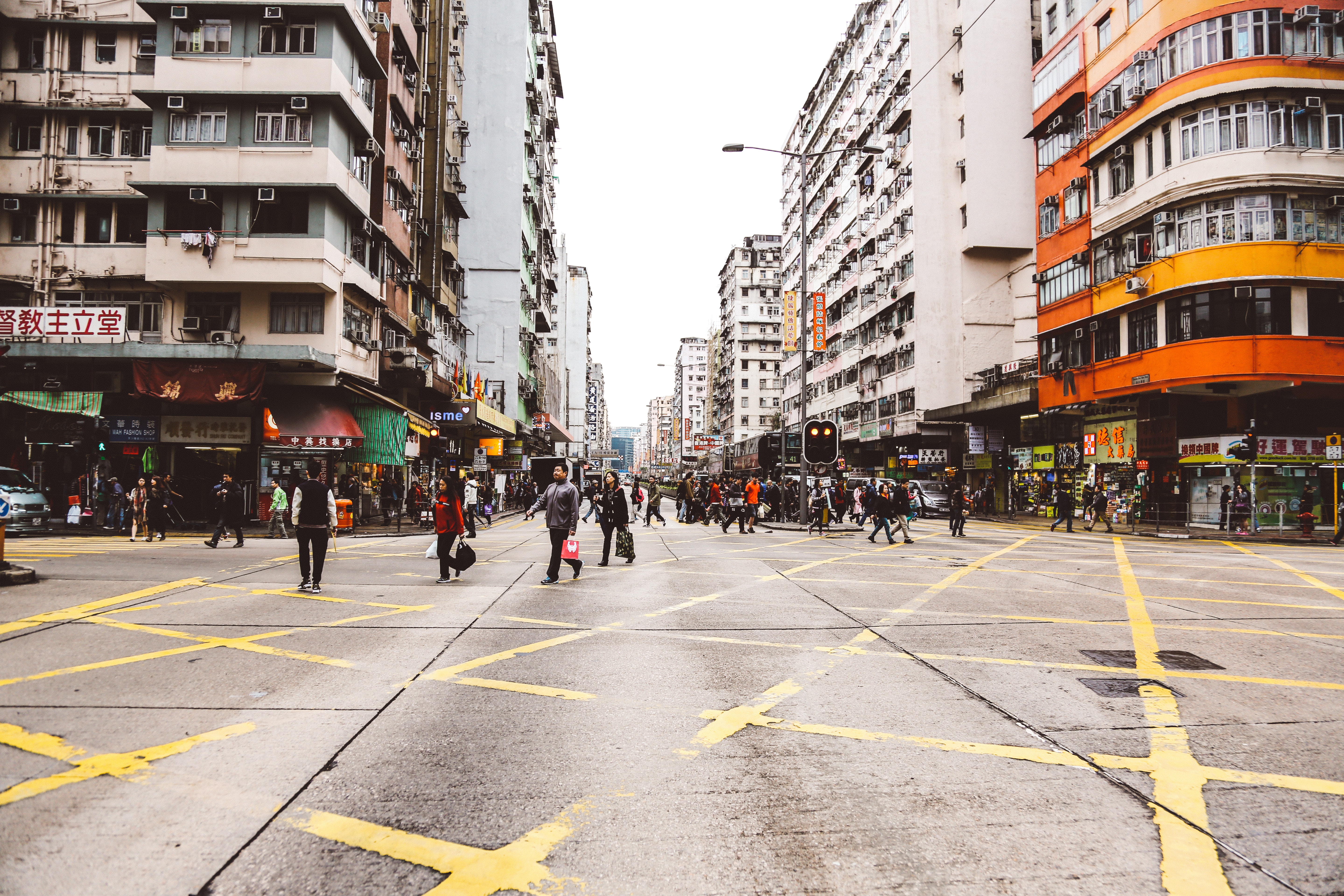 Busy street intersection with people crossing in a city HD Wallpaper