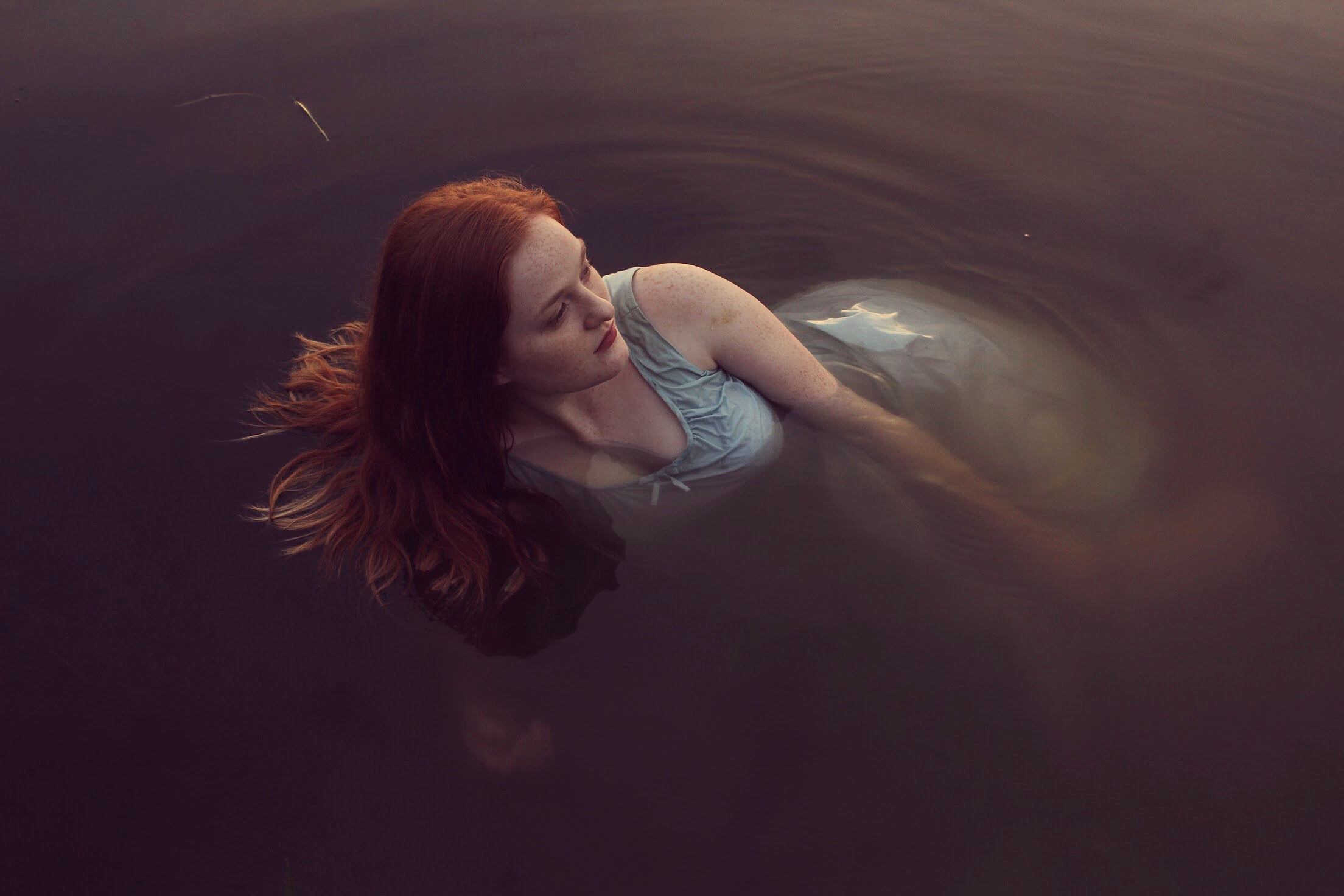 Woman with red hair floating in water HD Wallpaper