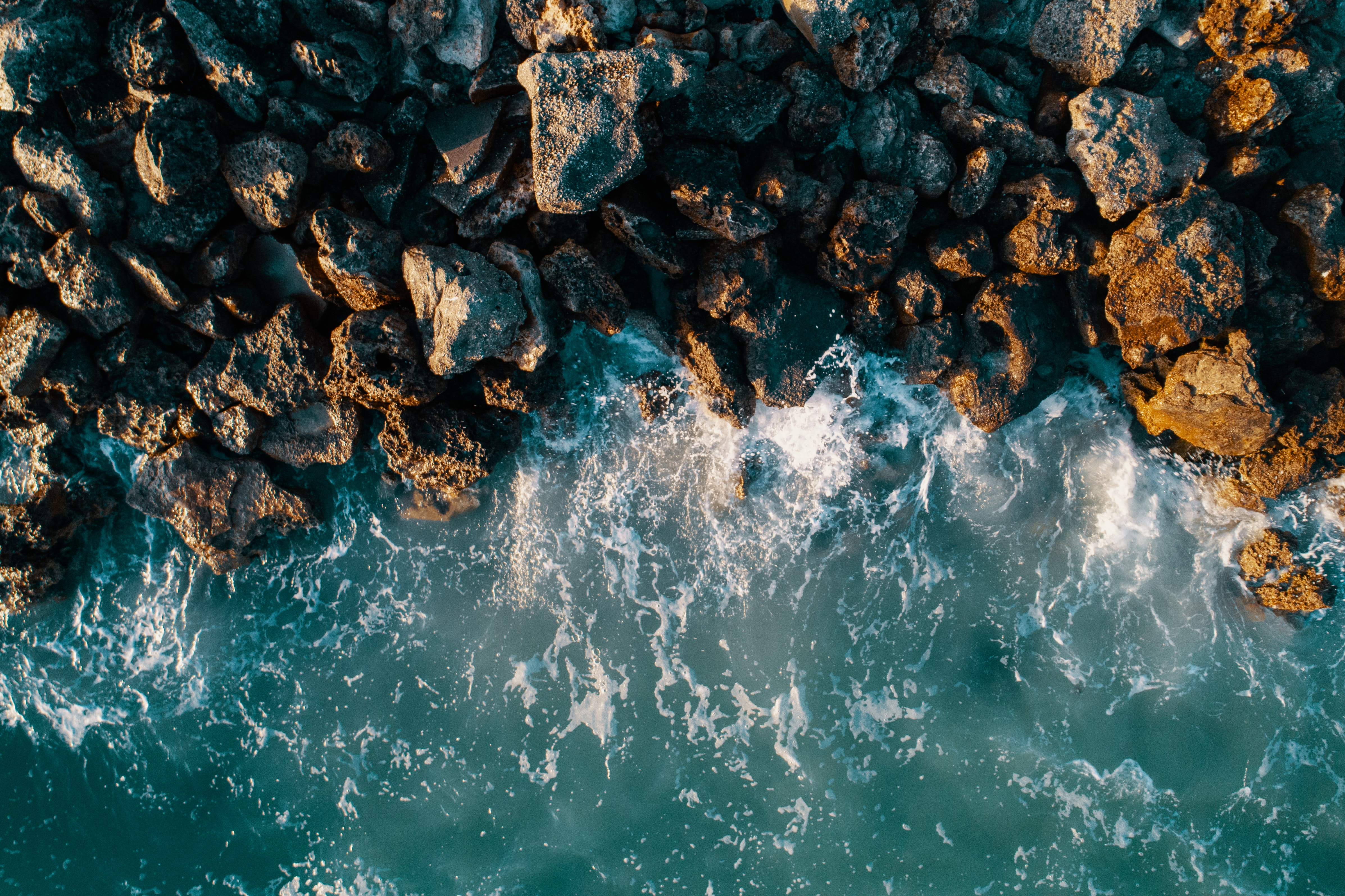Aerial view of ocean waves crashing on rocks HD Wallpaper
