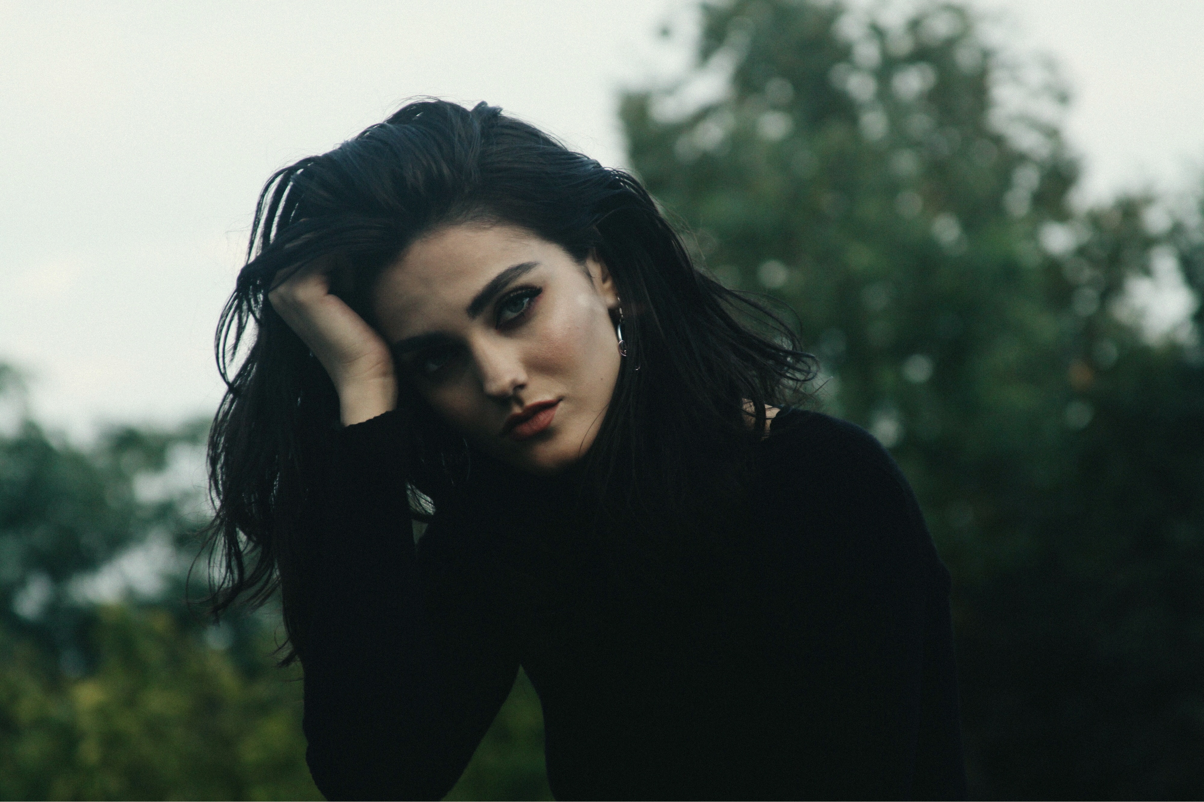 Woman with dark hair in a black top outdoors HD Wallpaper