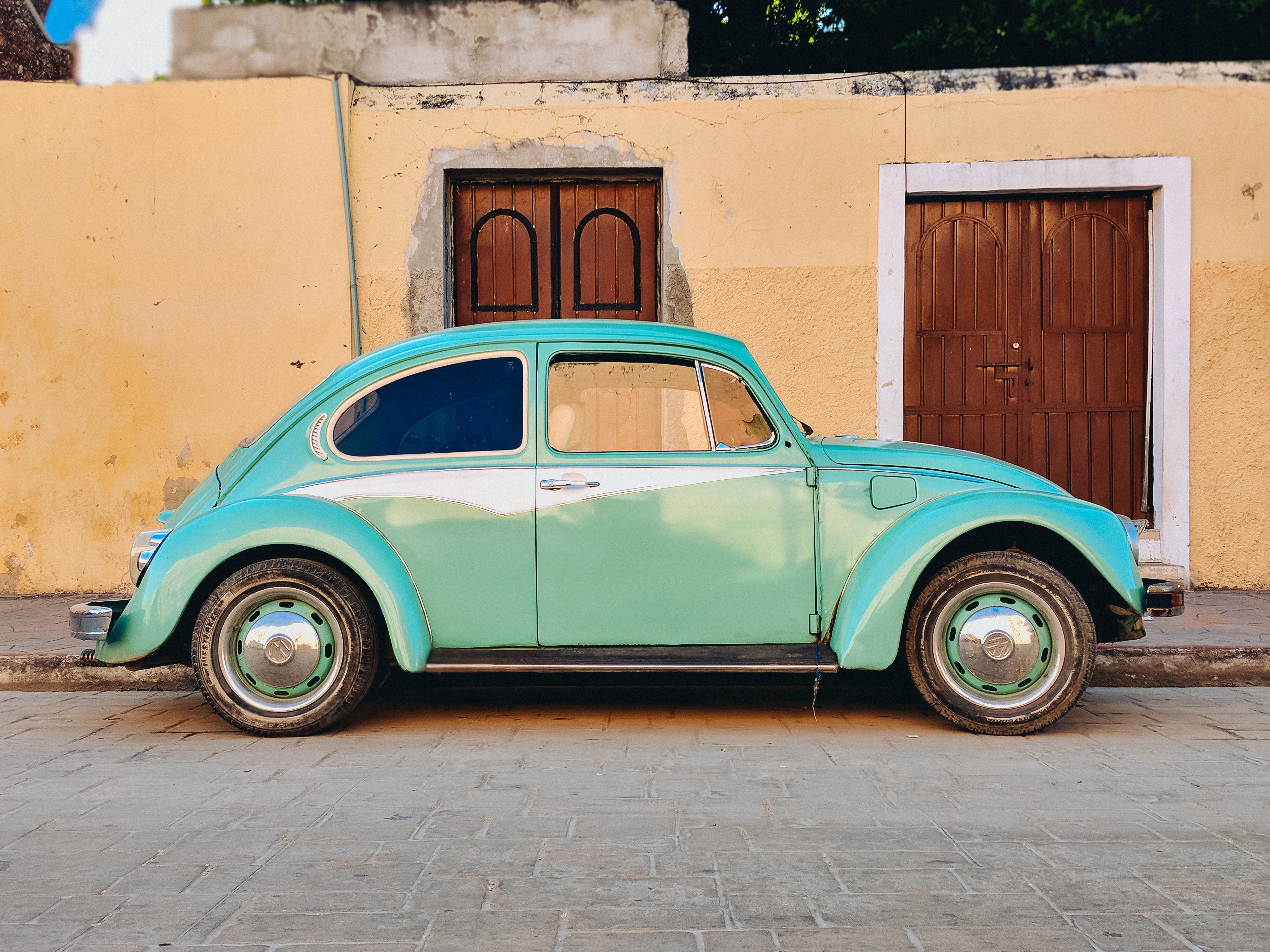 Aqua Volkswagen Beetle parked by a building HD Wallpaper