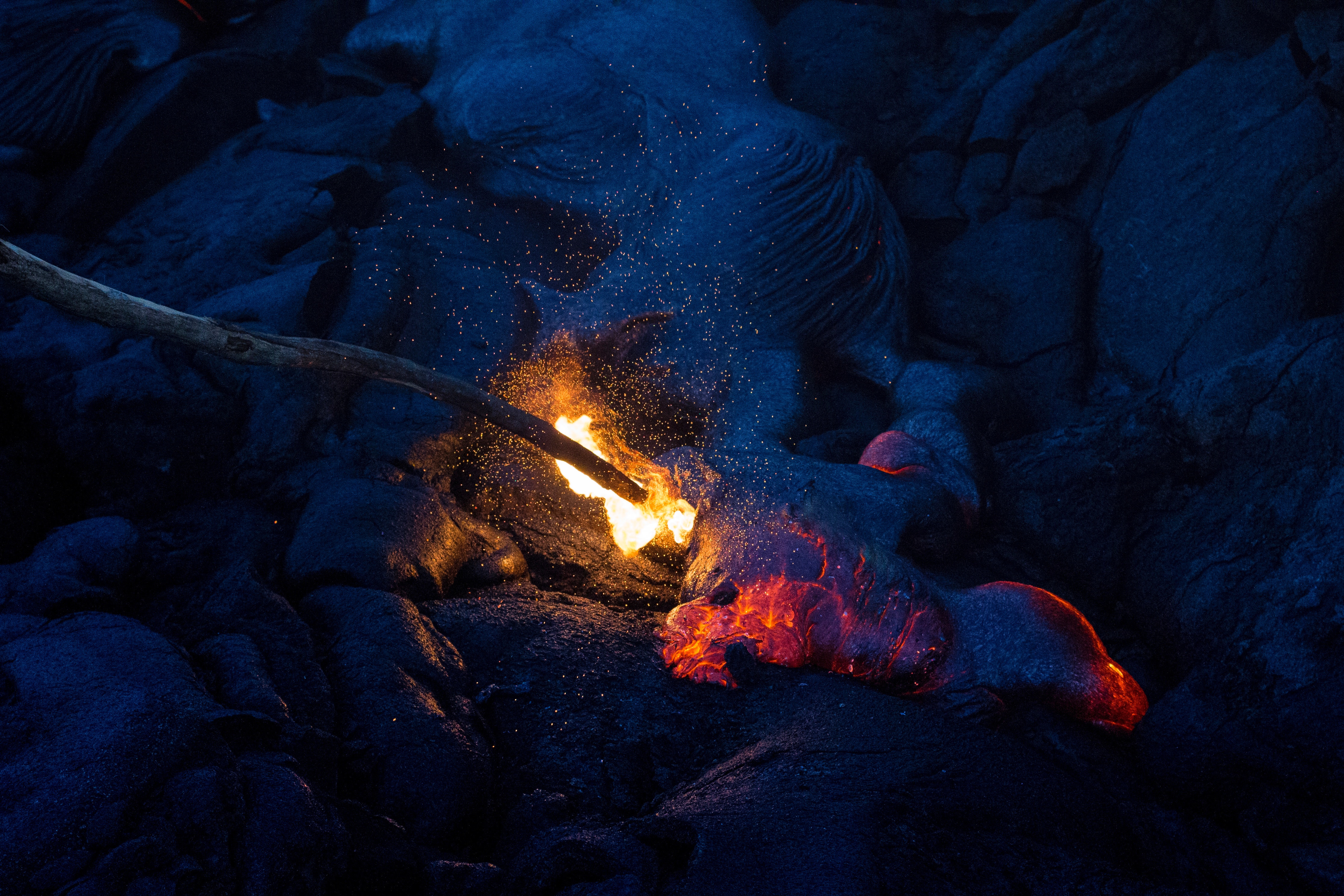 Stick igniting lava flow in Hawaii HD Wallpaper